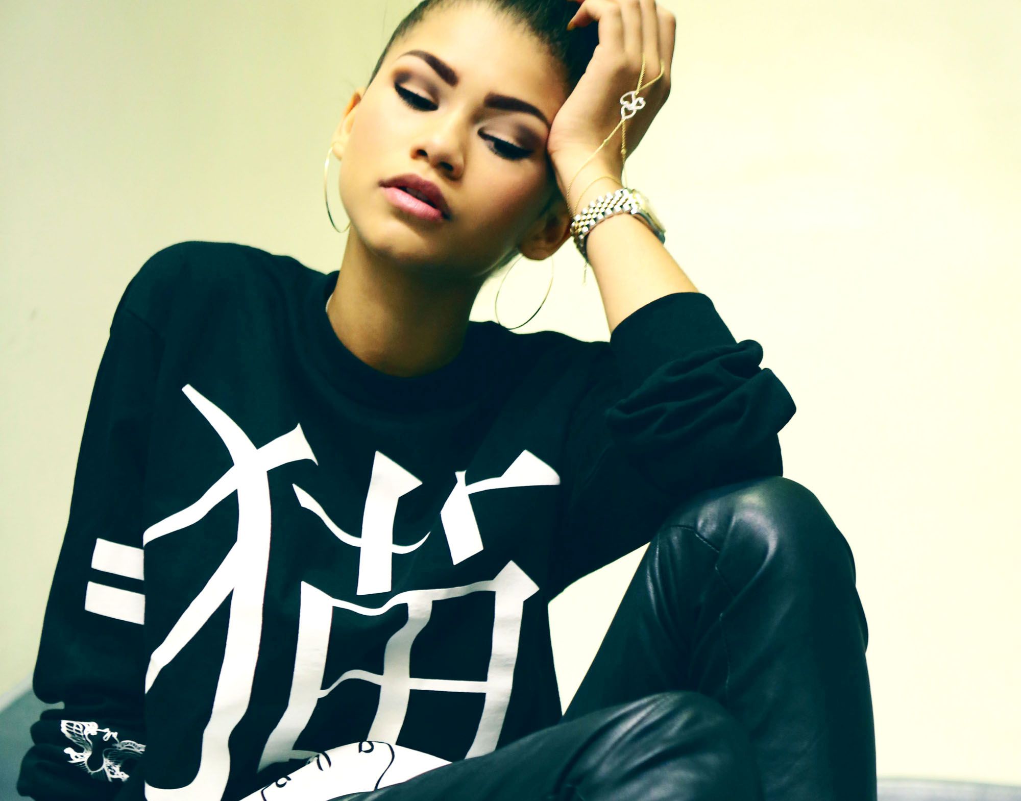 Zendaya wearing a black sweatshirt with white Japanese characters HD Wallpaper