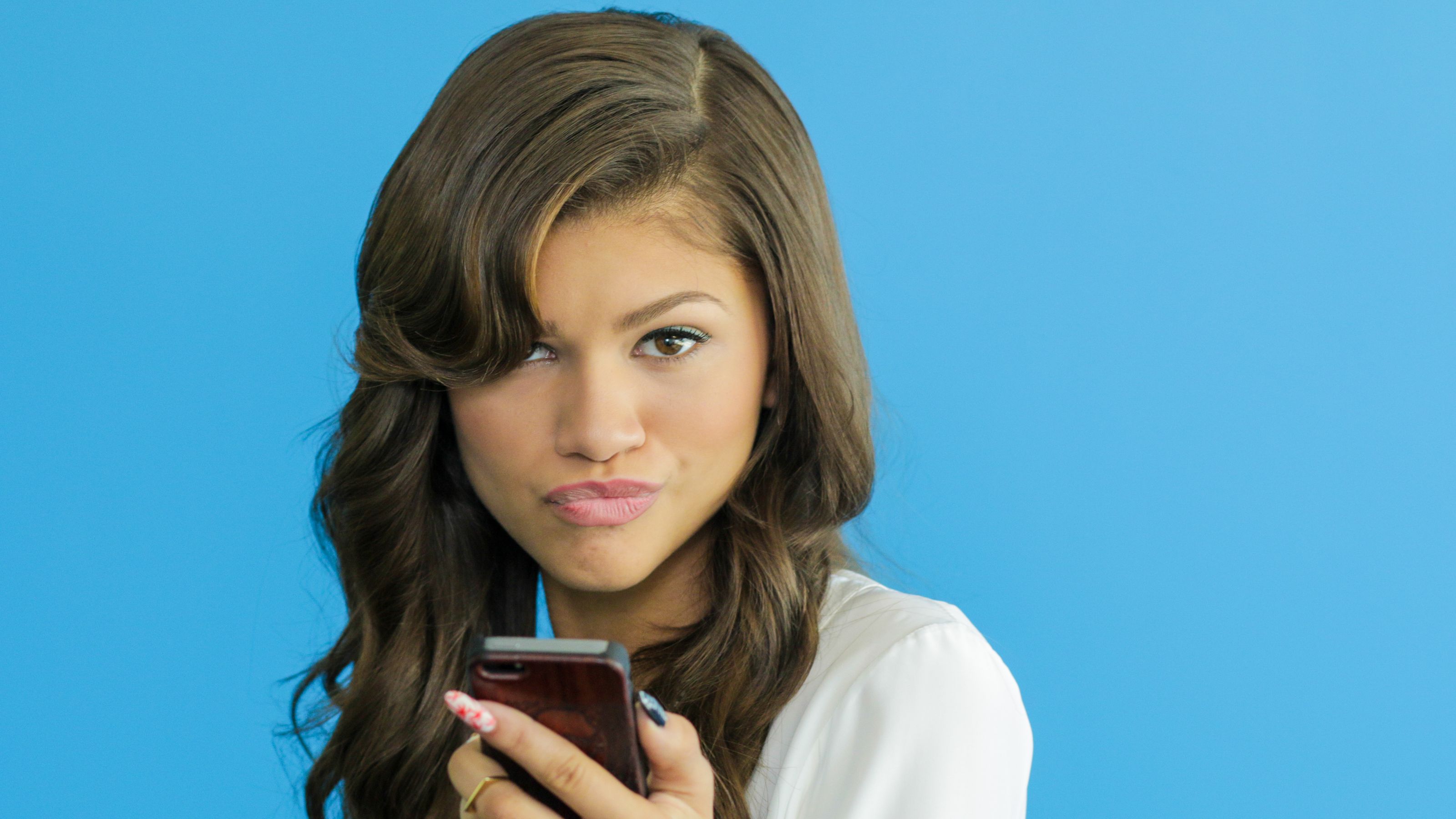 Zendaya holding a smartphone HD Wallpaper