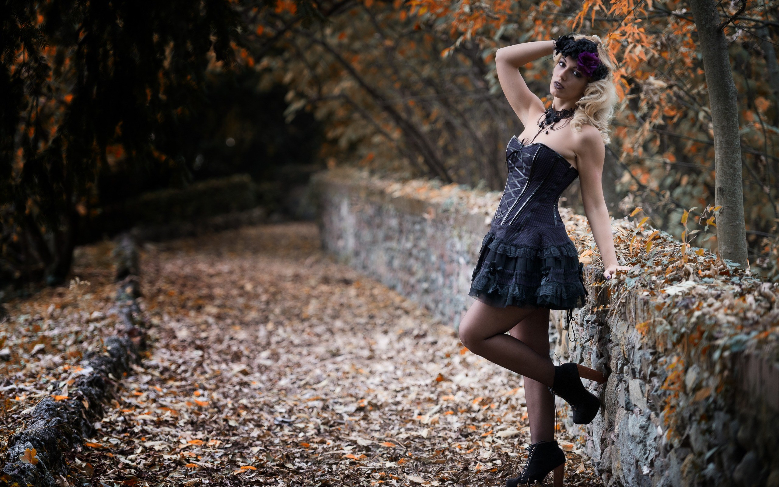 Woman in gothic dress posing by a stone wall HD Wallpaper