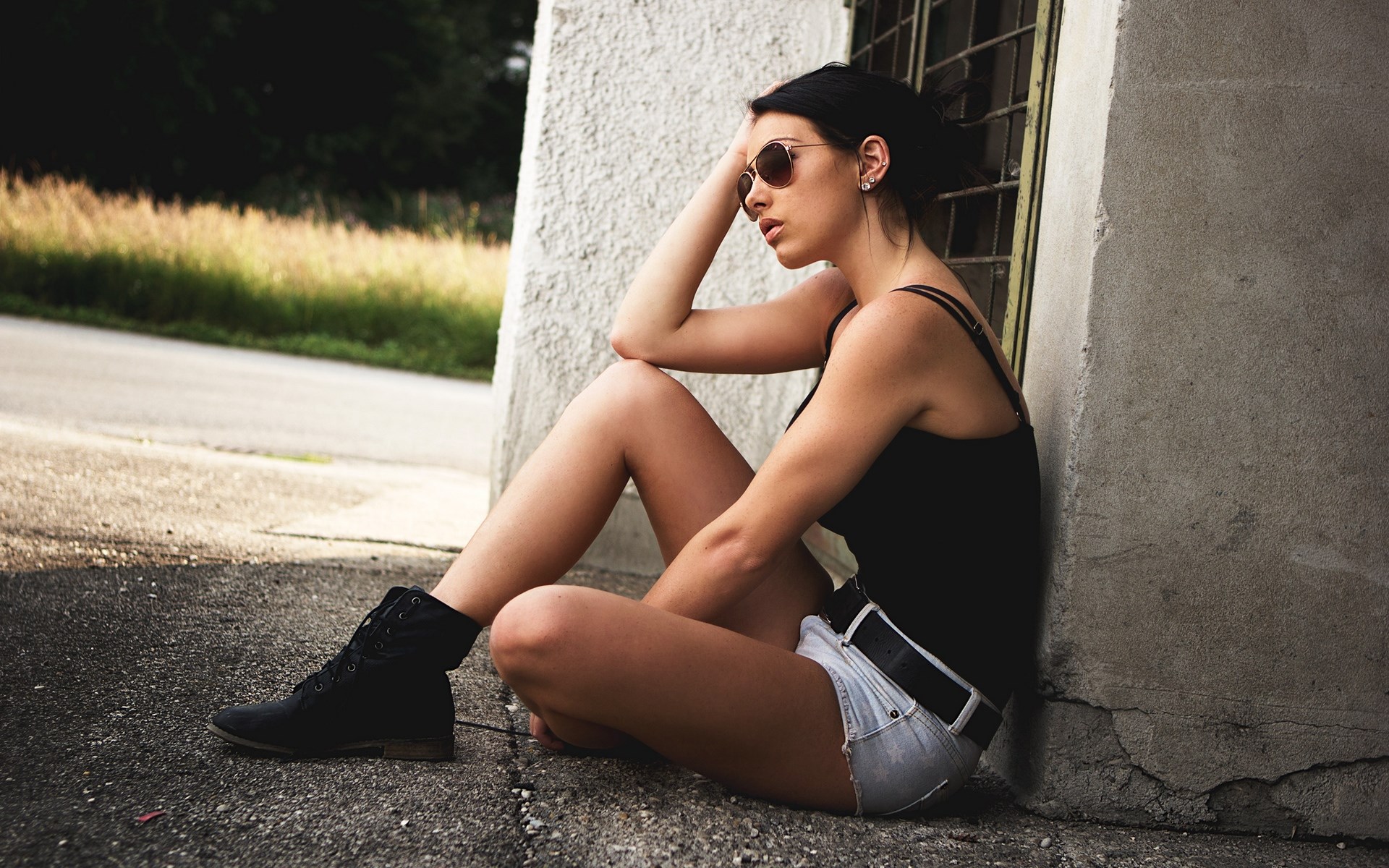 Woman in shorts and boots sitting by a wall HD Wallpaper