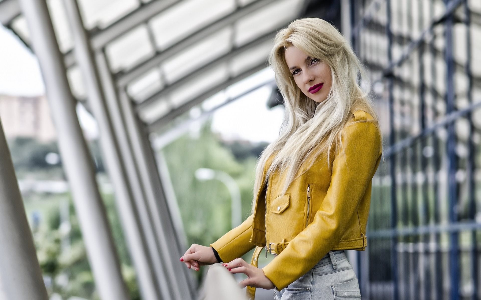 Woman in yellow jacket leaning on railing HD Wallpaper
