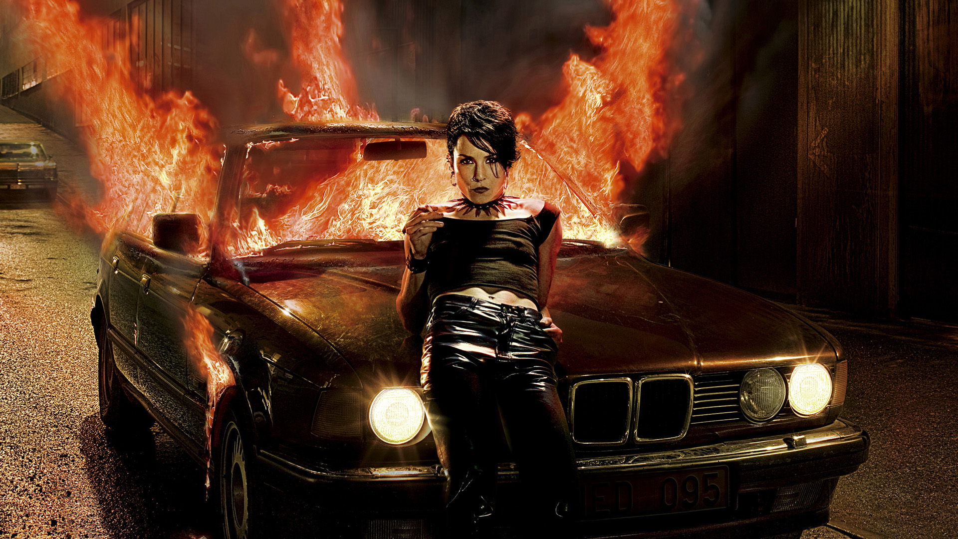 Noomi Rapace in front of a burning car HD Wallpaper