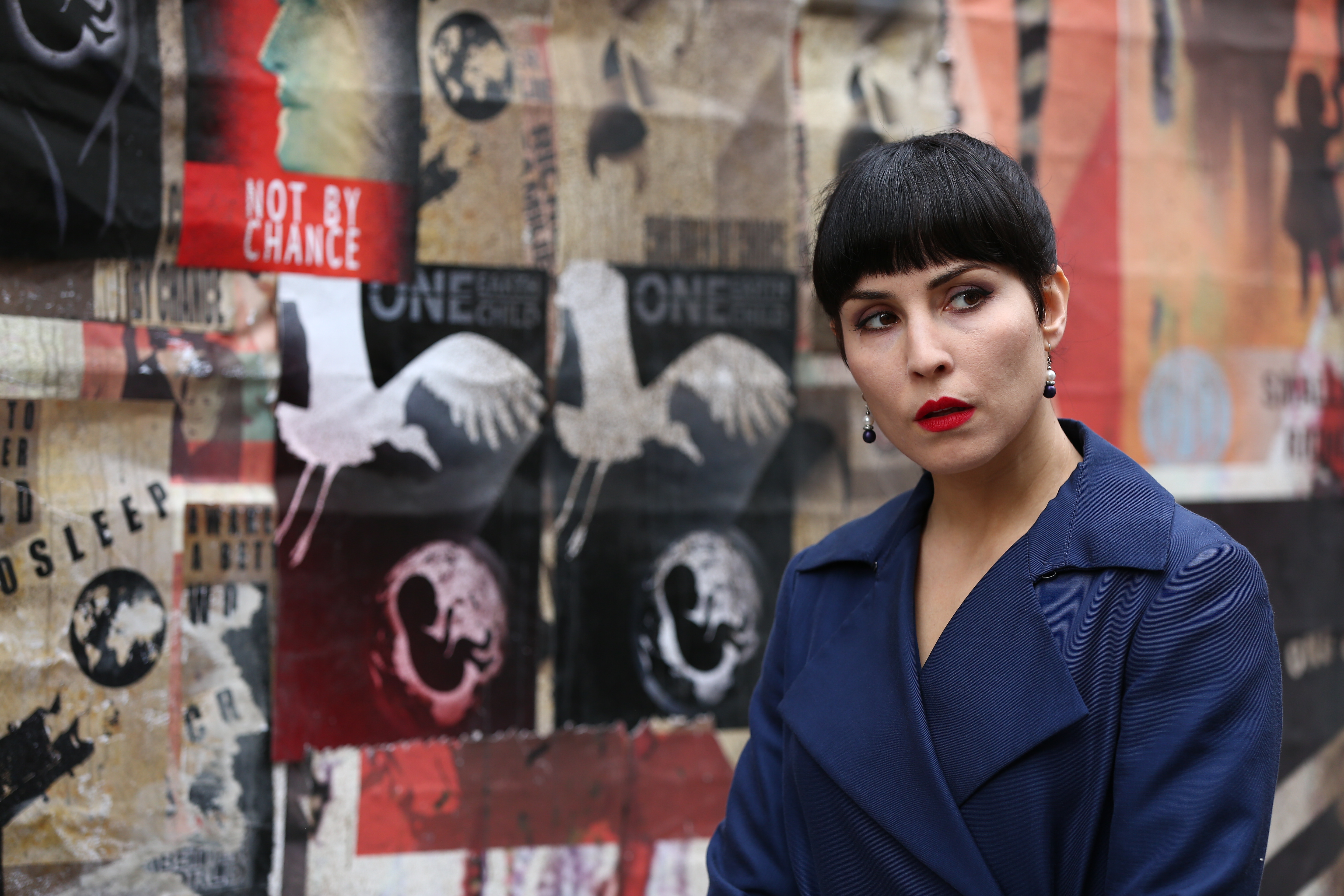 Noomi Rapace in front of a collage of posters HD Wallpaper