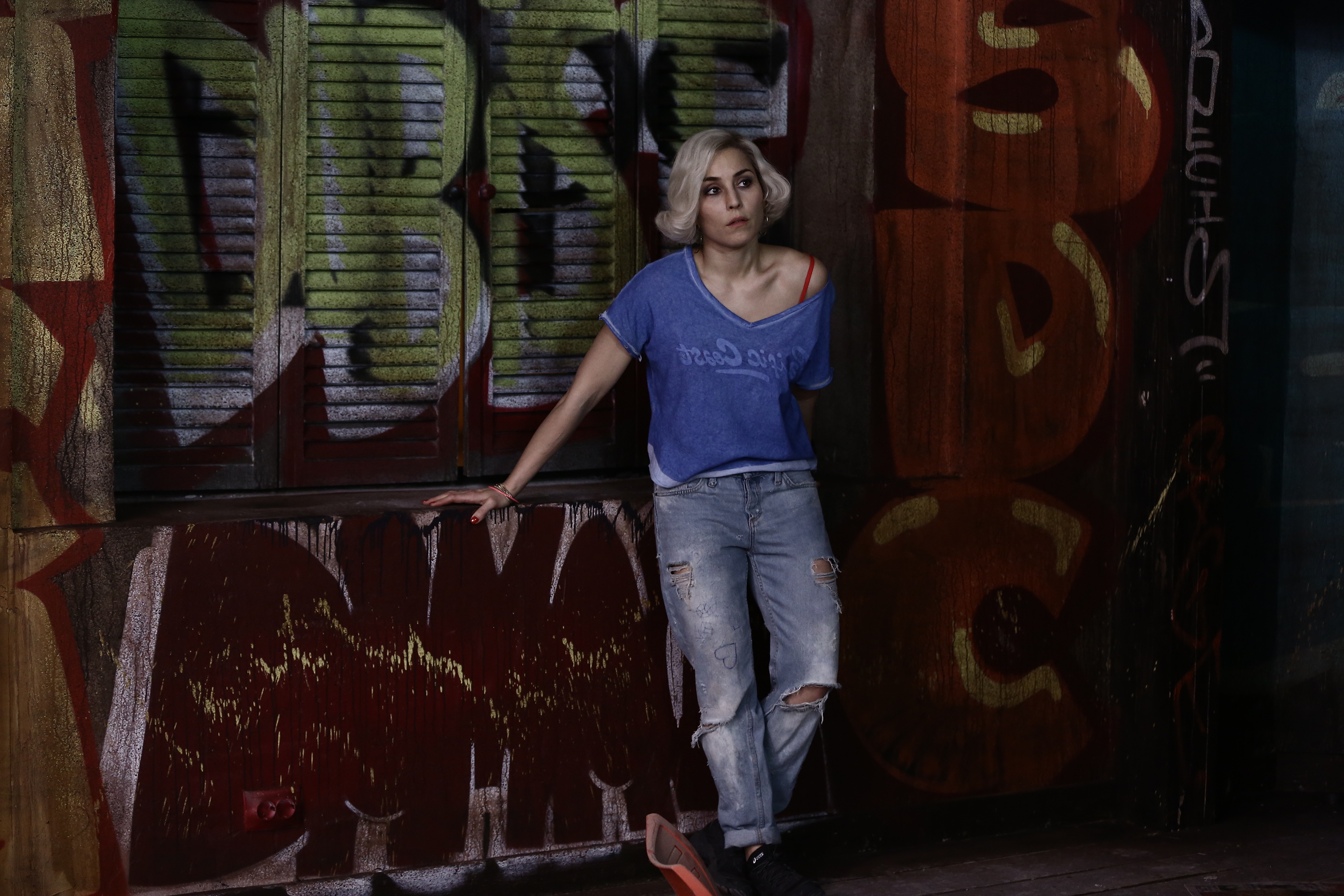 Noomi Rapace leaning against graffiti wall HD Wallpaper