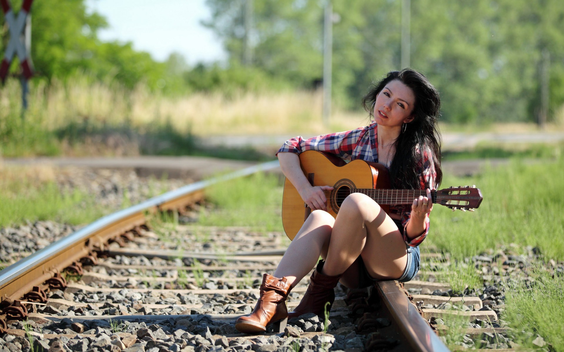 Woman playing guitar on train tracks HD Wallpaper