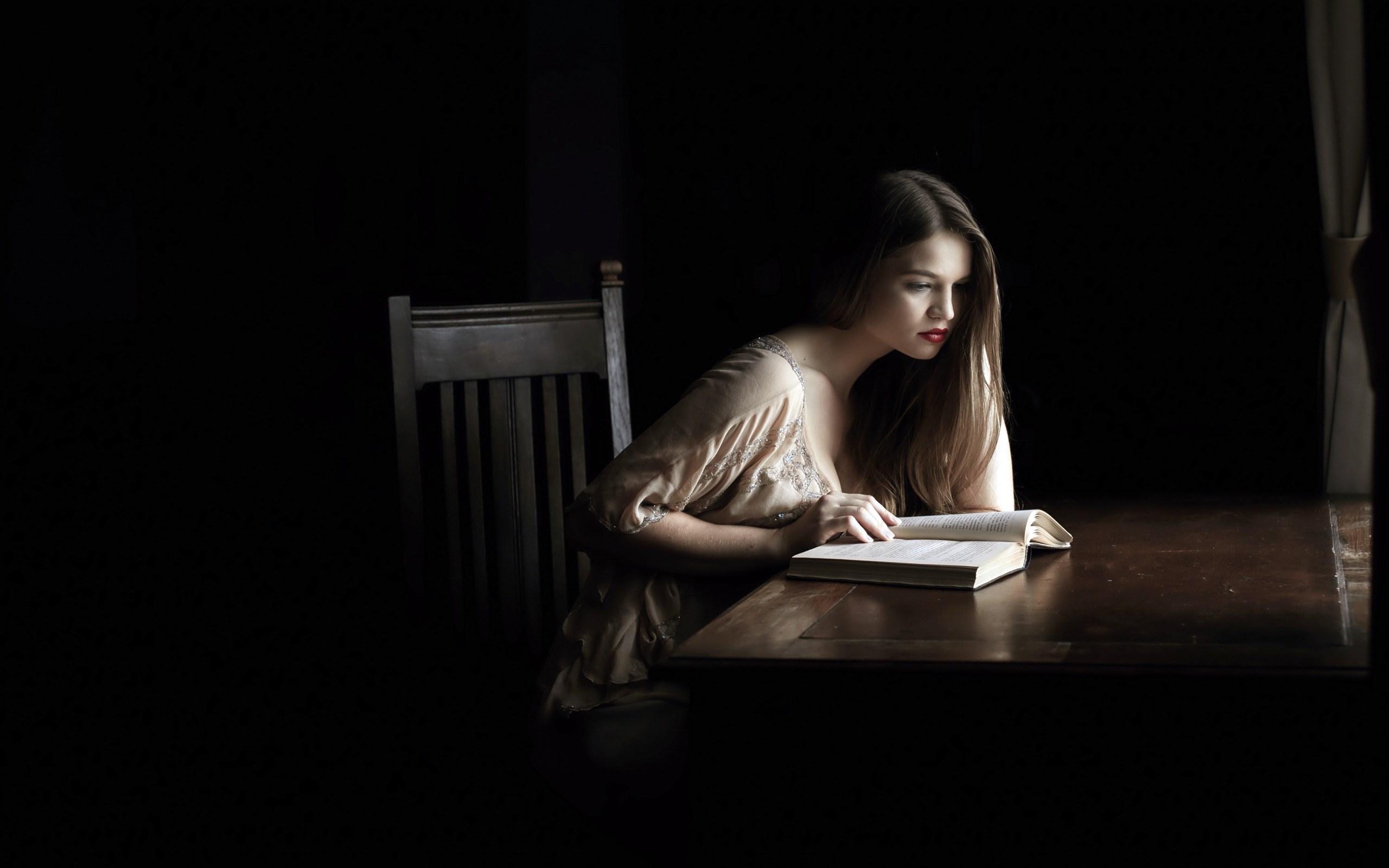 Woman reading a book at a table HD Wallpaper