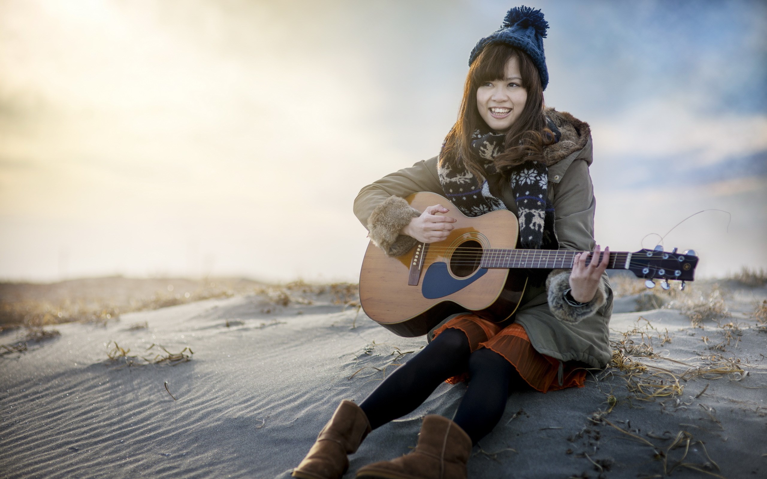 Woman playing guitar on a sandy beach HD Wallpaper