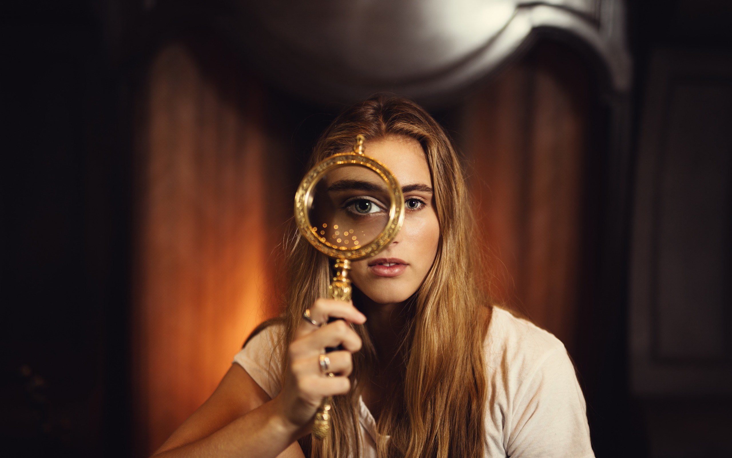 Woman looking through a magnifying glass HD Wallpaper