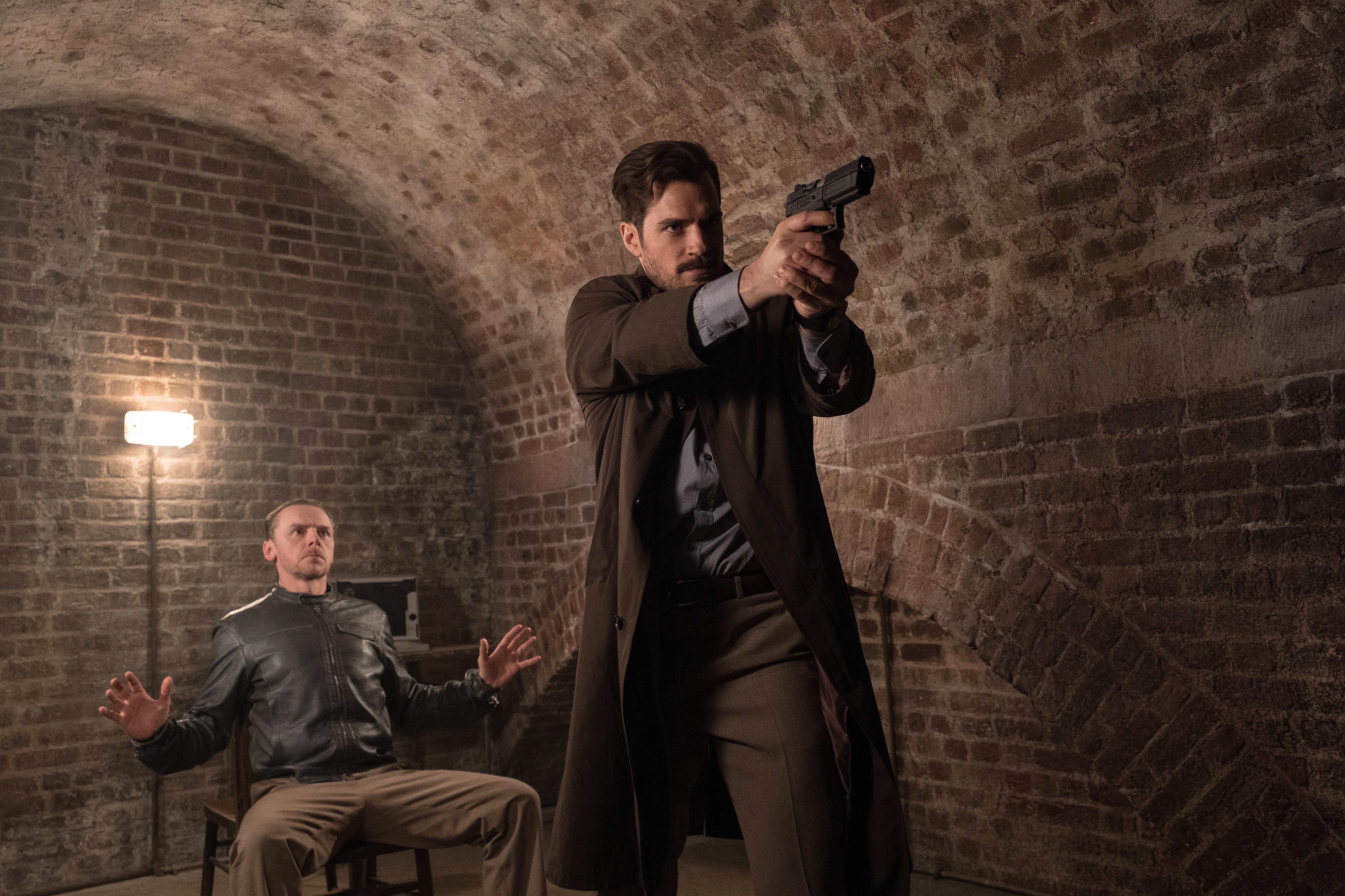 Simon Pegg in a brick room with a man holding a gun HD Wallpaper