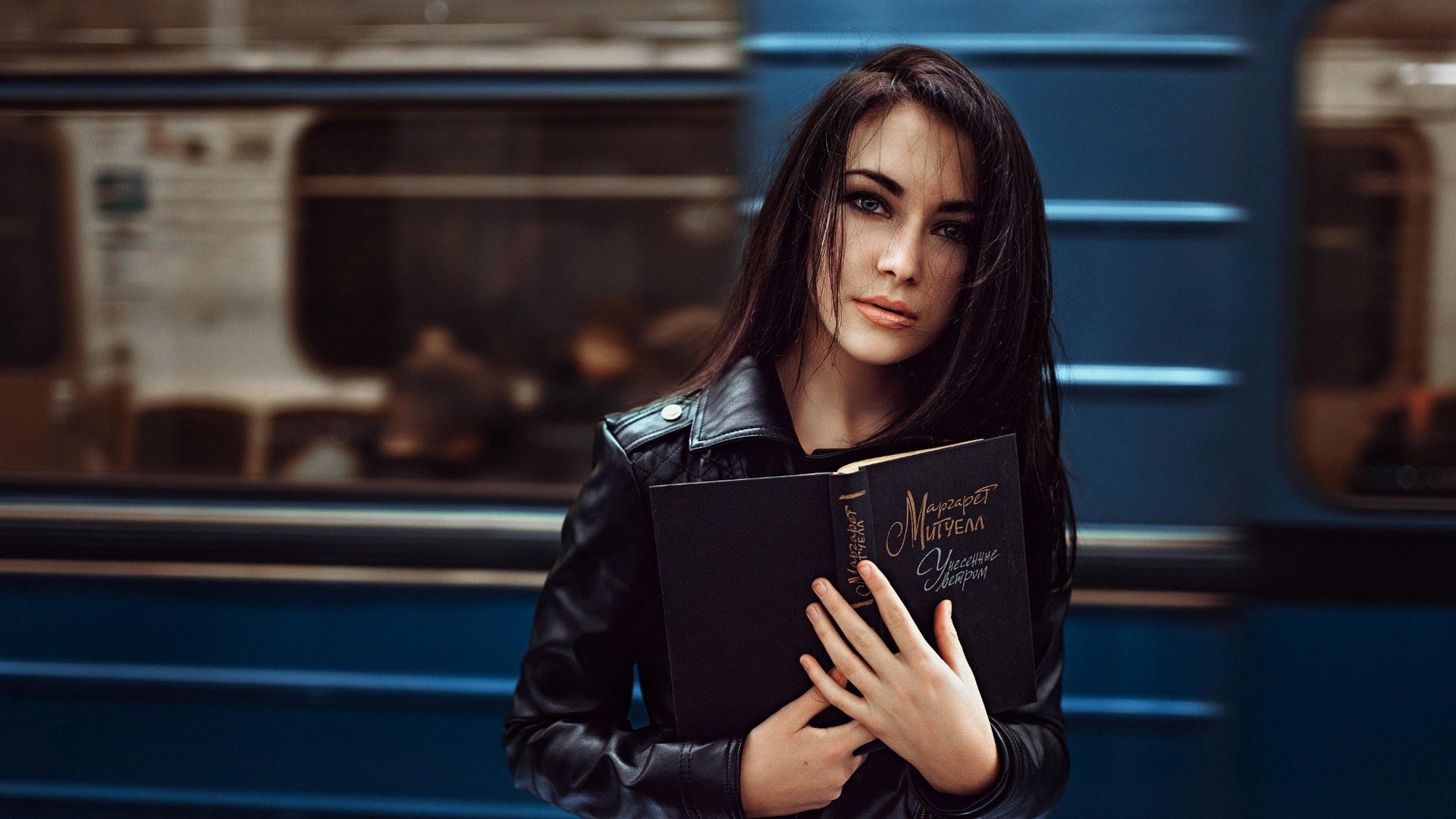 Woman holding a book in front of a train HD Wallpaper