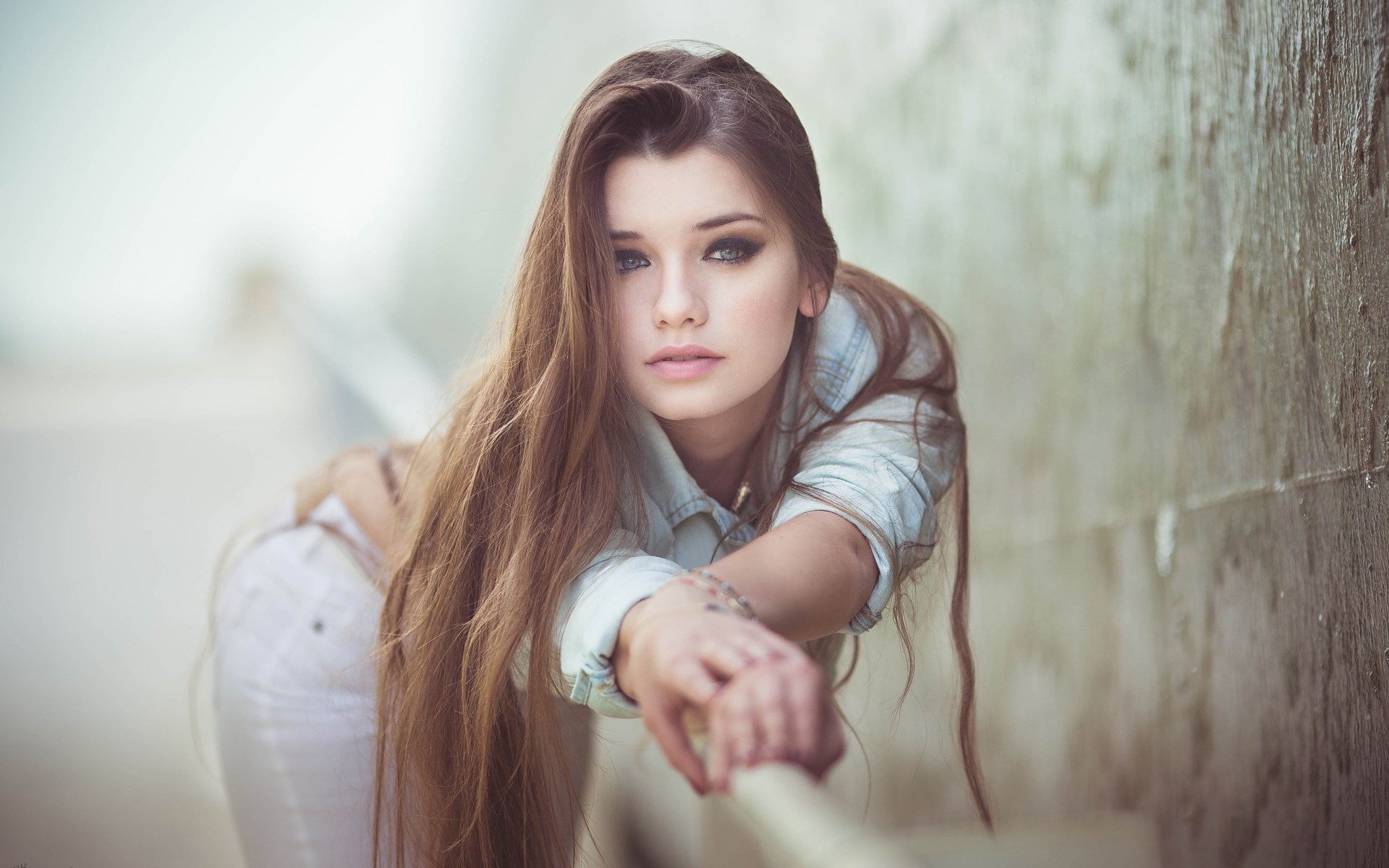 Young woman leaning on a railing HD Wallpaper