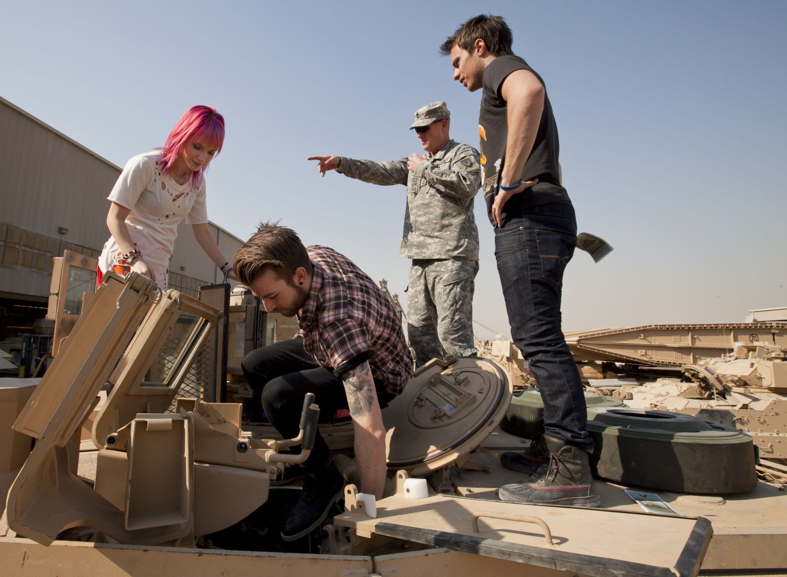 Hayley Williams with soldiers near a tank HD Wallpaper