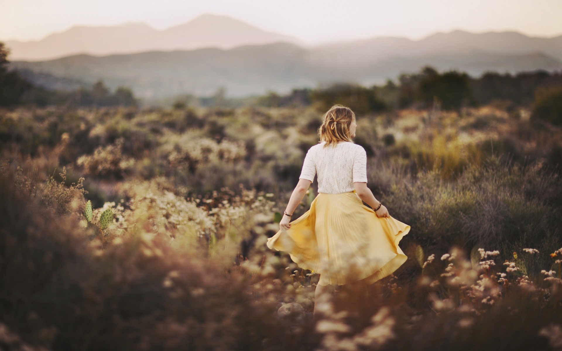 Woman in yellow skirt in a field at sunset HD Wallpaper