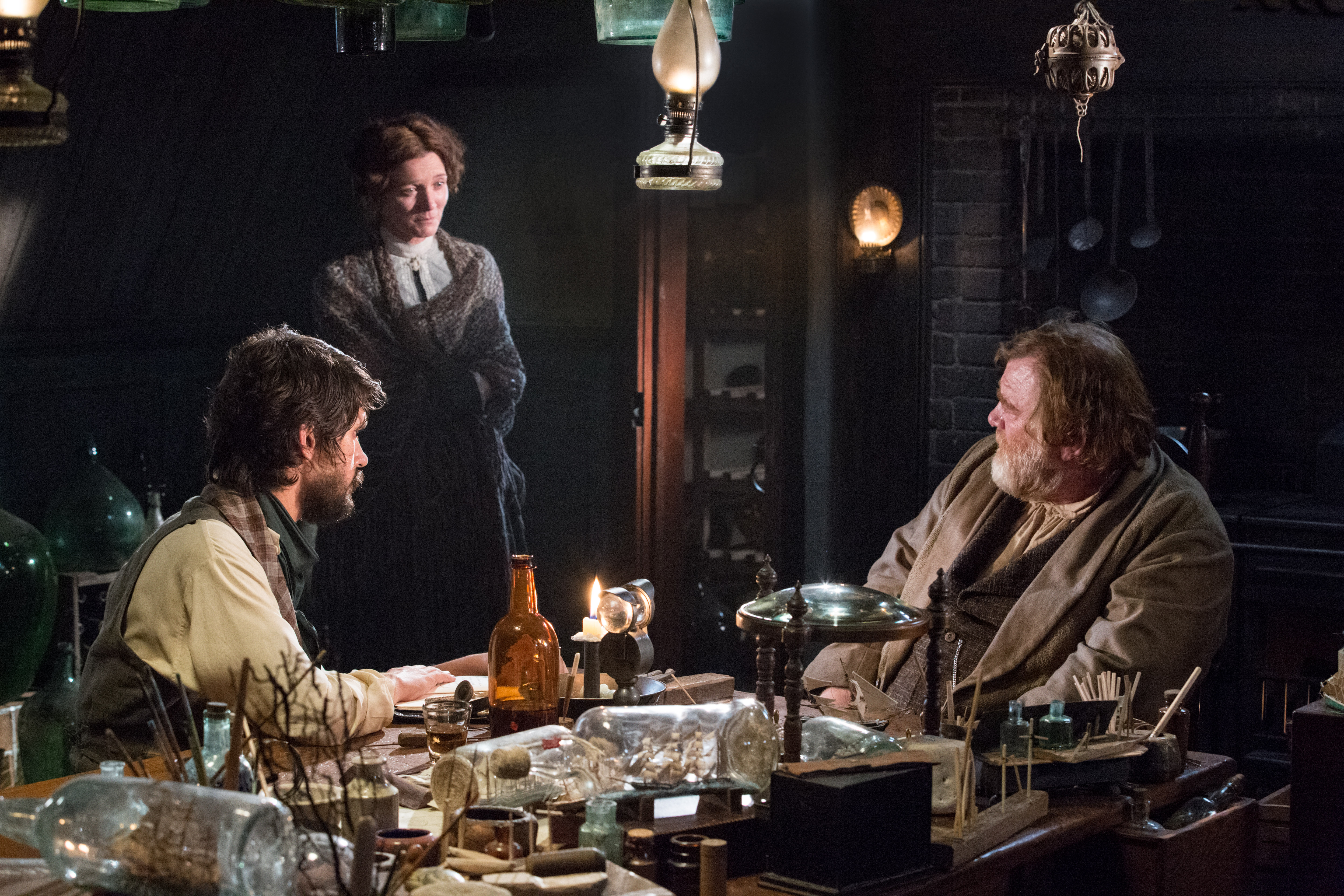 Michelle Fairley and two men in a dimly lit room HD Wallpaper