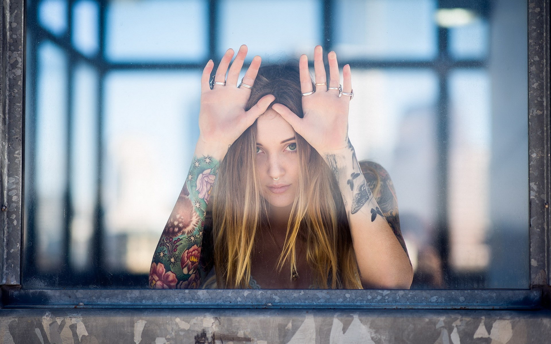 Woman with tattoos looking through a window HD Wallpaper