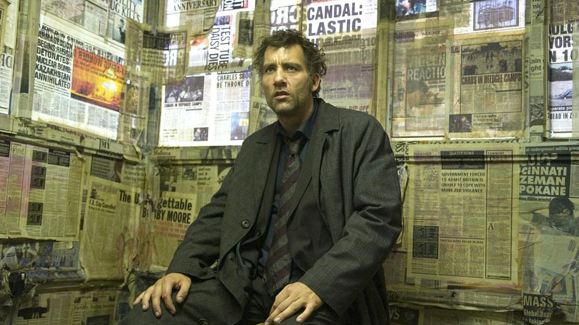 Clive Owen in a room covered in newspapers HD Wallpaper