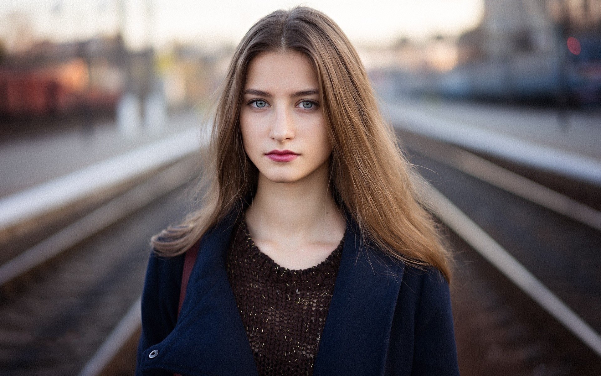 Young woman with long brown hair on train tracks HD Wallpaper