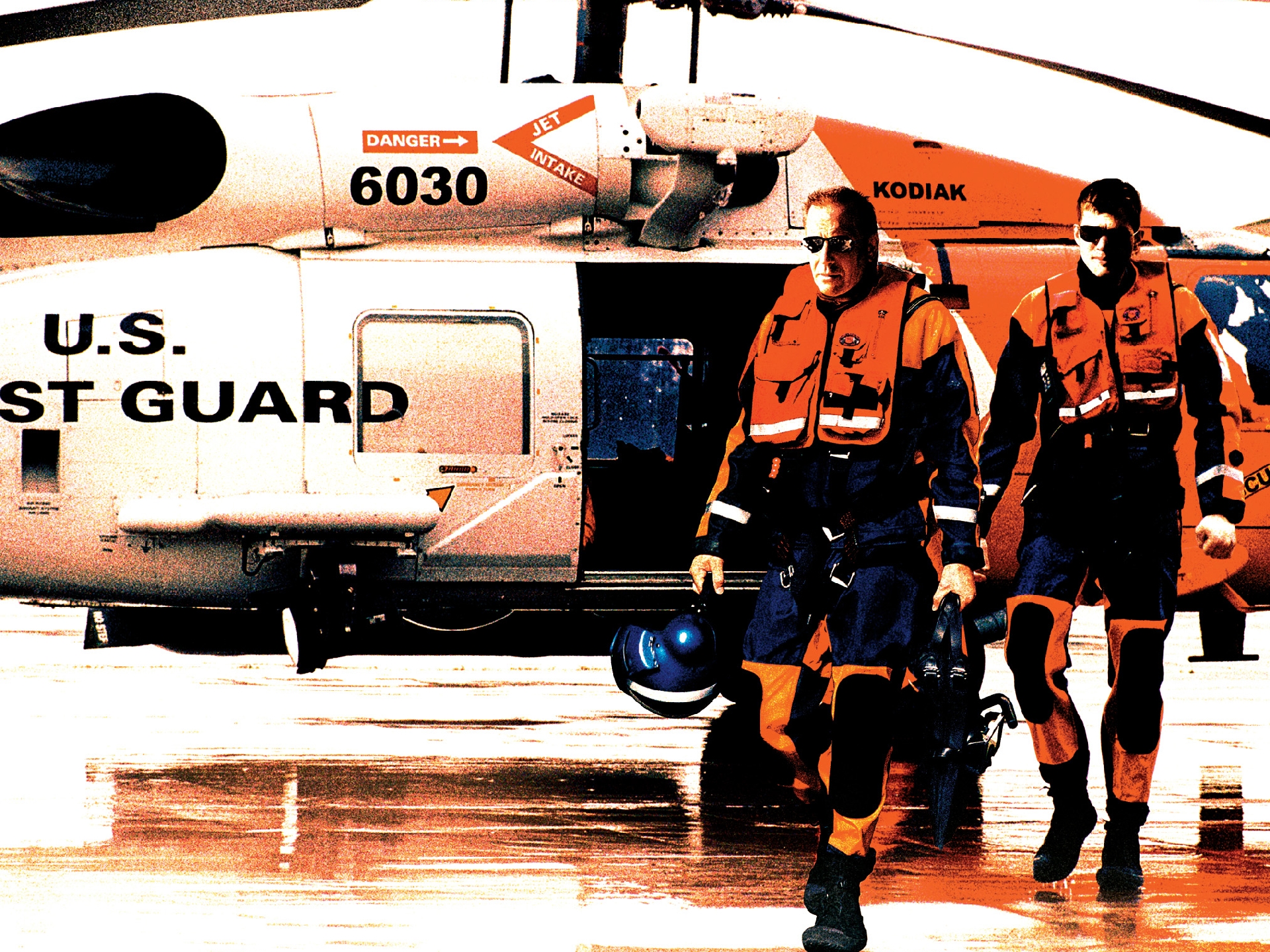 Two U.S. Coast Guard members walk by a helicopter HD Wallpaper