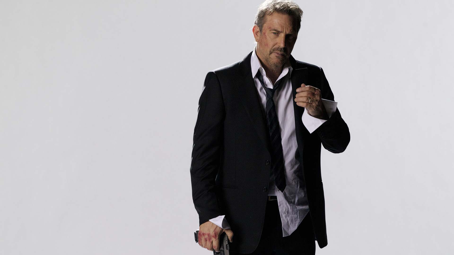 Kevin Costner in a suit holding a gun HD Wallpaper