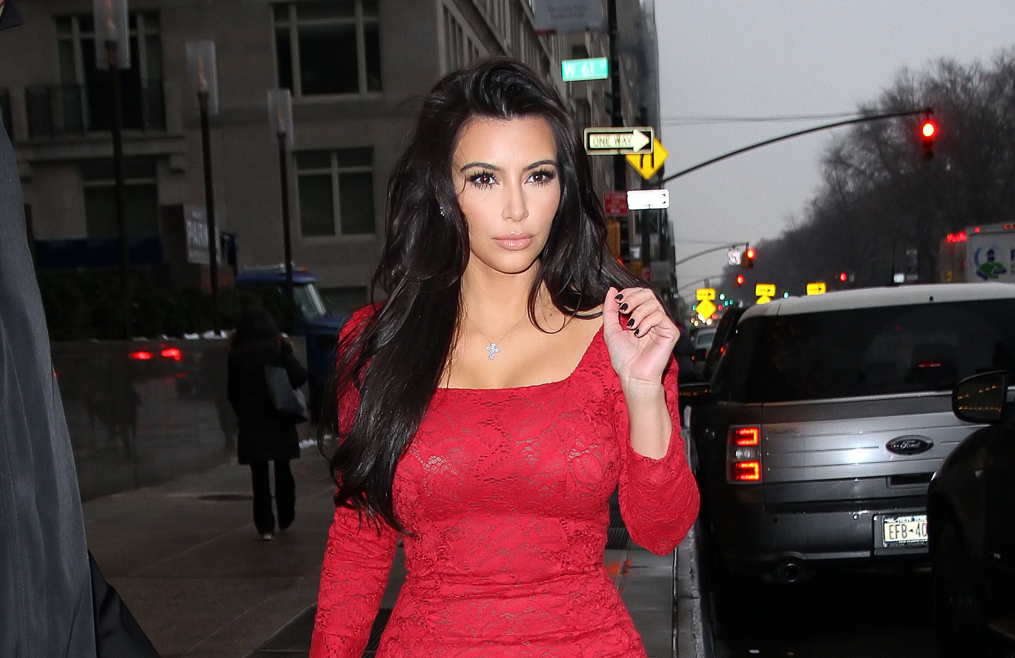 Kim Kardashian in a red dress on a city street HD Wallpaper
