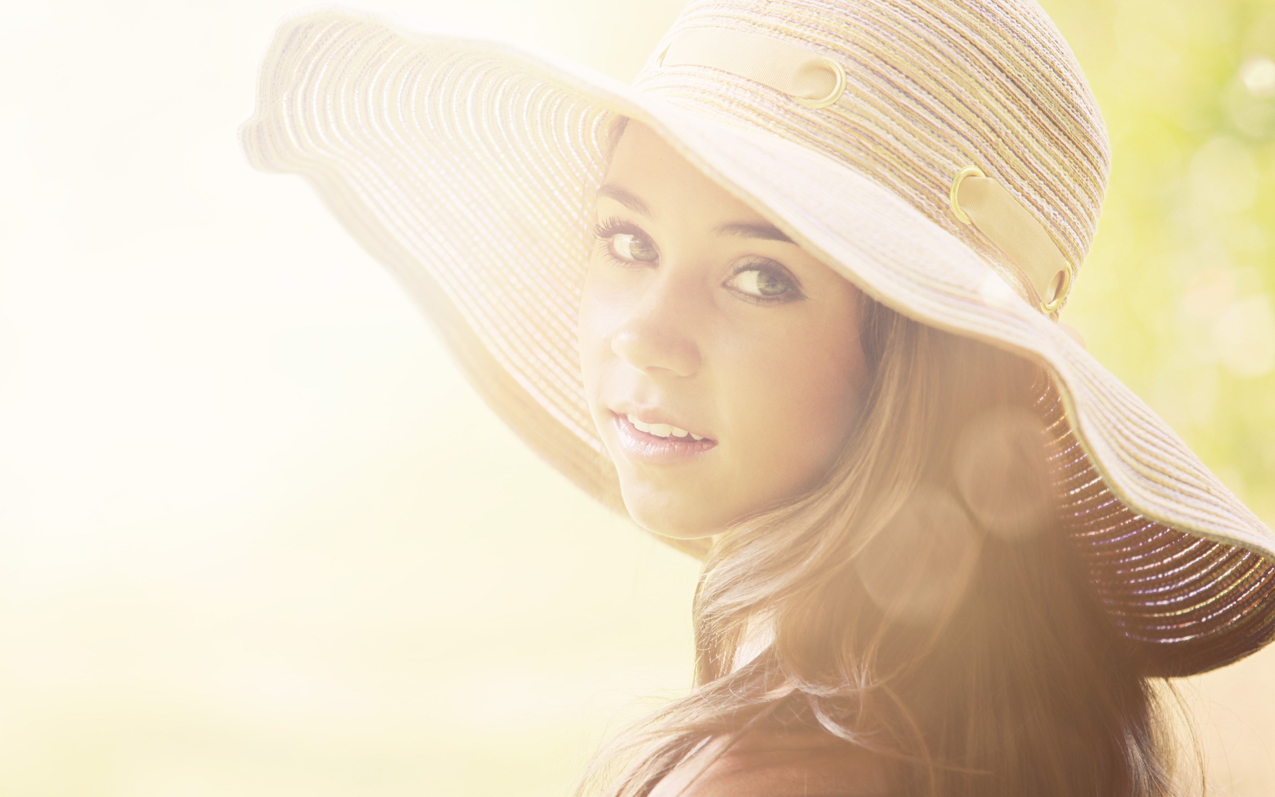 Woman in a wide-brimmed hat looking over her shoulder HD Wallpaper