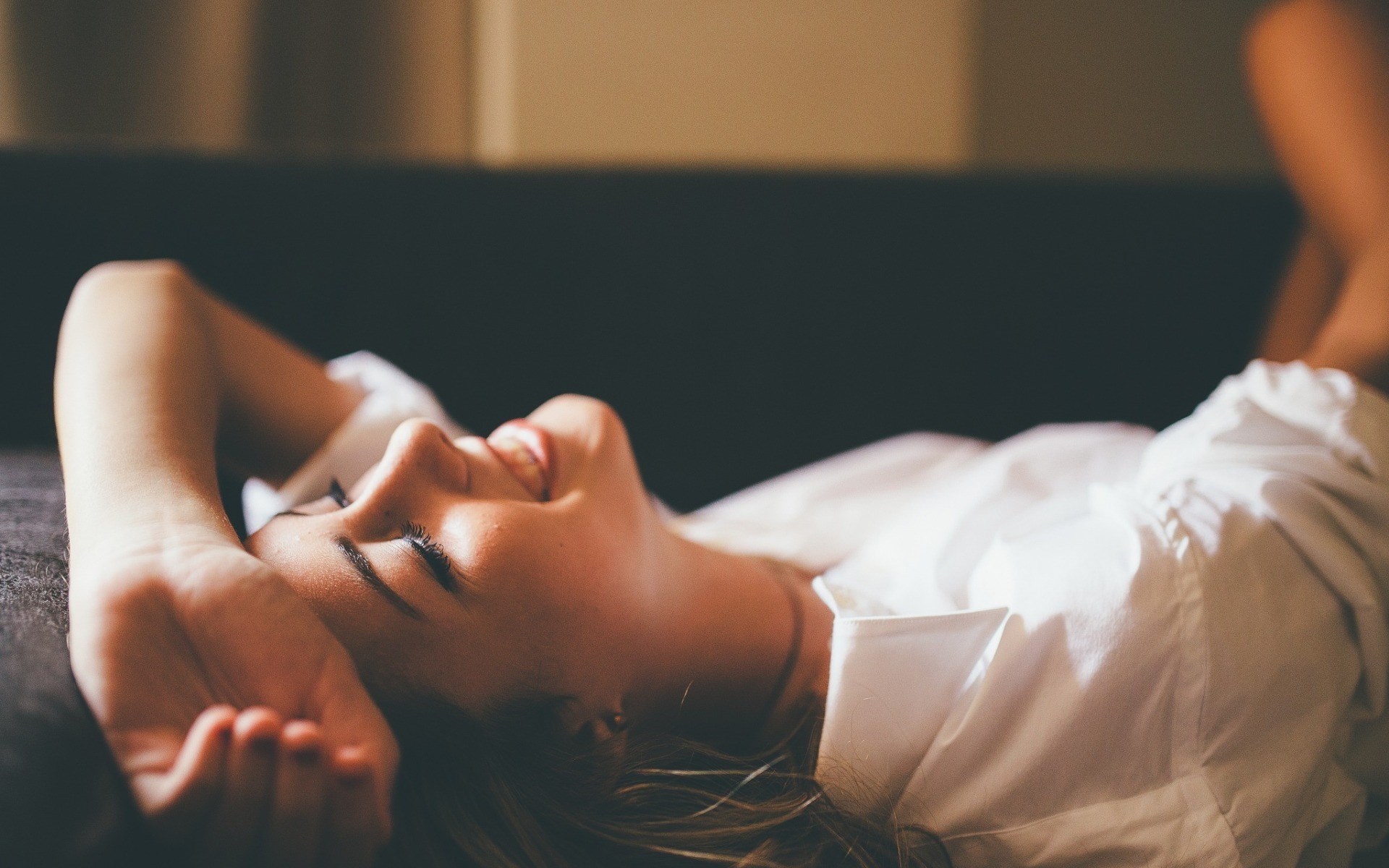 Woman in white shirt lying on couch HD Wallpaper