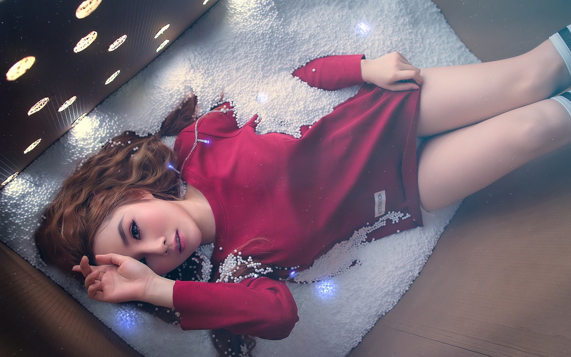 Woman in red dress lying in a box with white beads HD Wallpaper