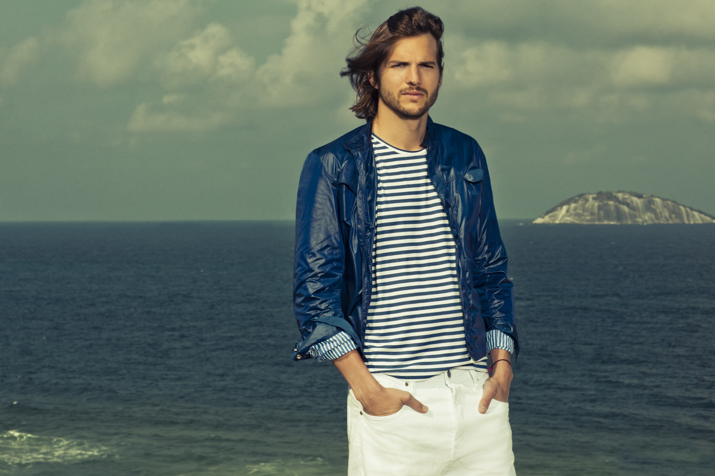 Ashton Kutcher on a beach with an island in the background HD Wallpaper