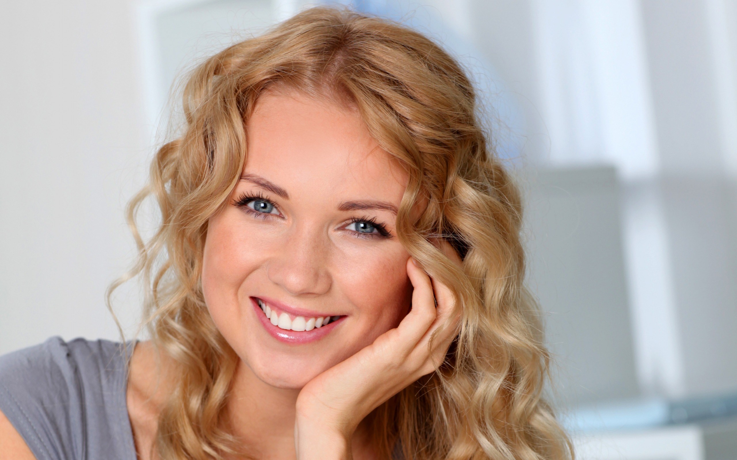 Woman with blonde curly hair smiling HD Wallpaper