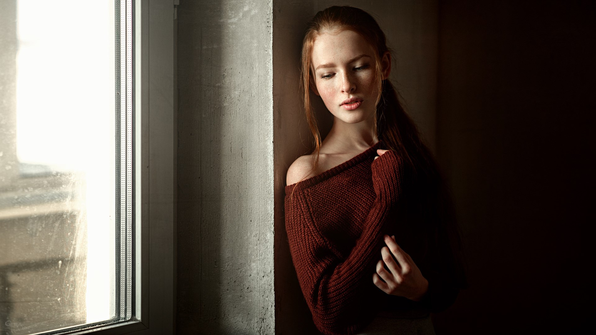 Young woman with red hair by a window HD Wallpaper