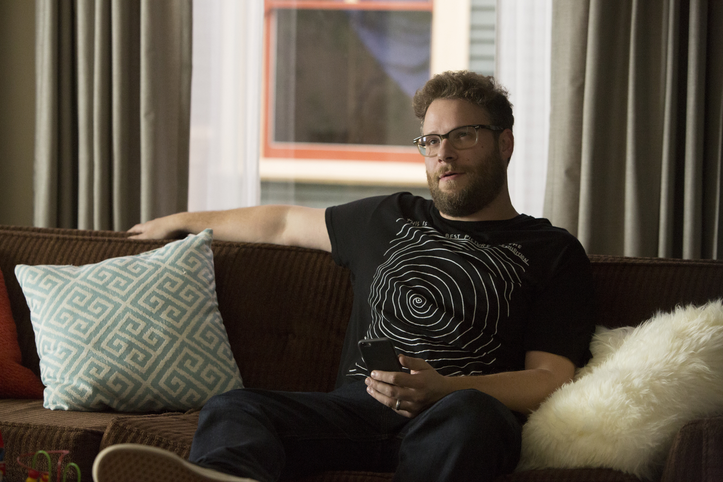 Seth Rogen sitting on a couch HD Wallpaper