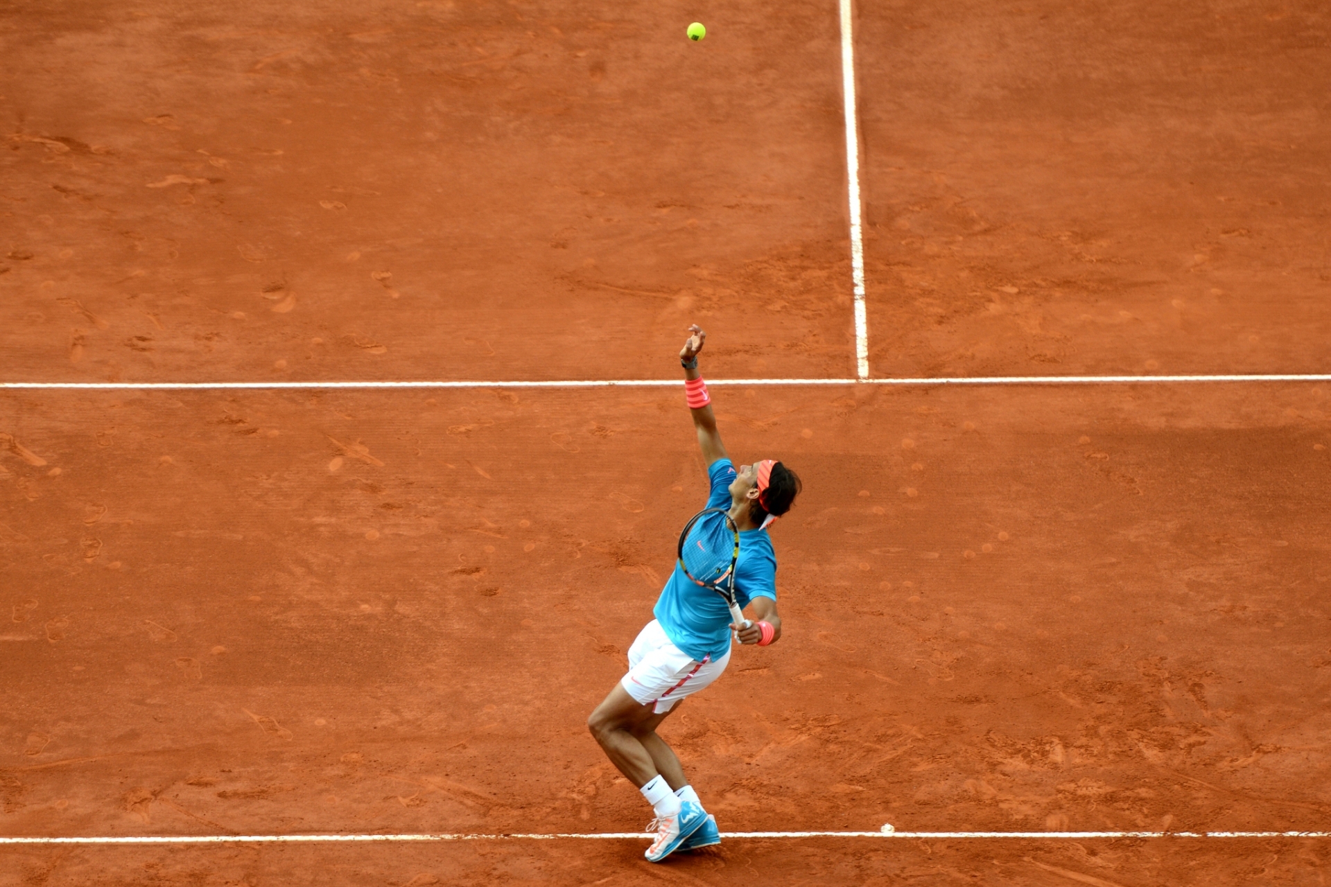 Rafael Nadal serving on a clay tennis court HD Wallpaper