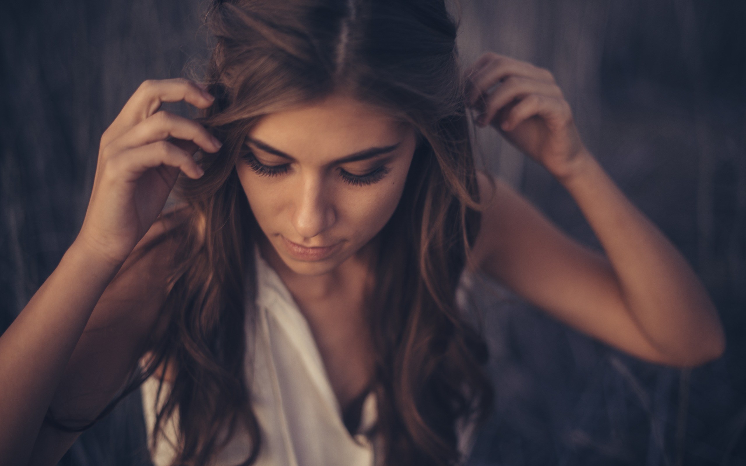 Woman with long wavy hair touching her head HD Wallpaper