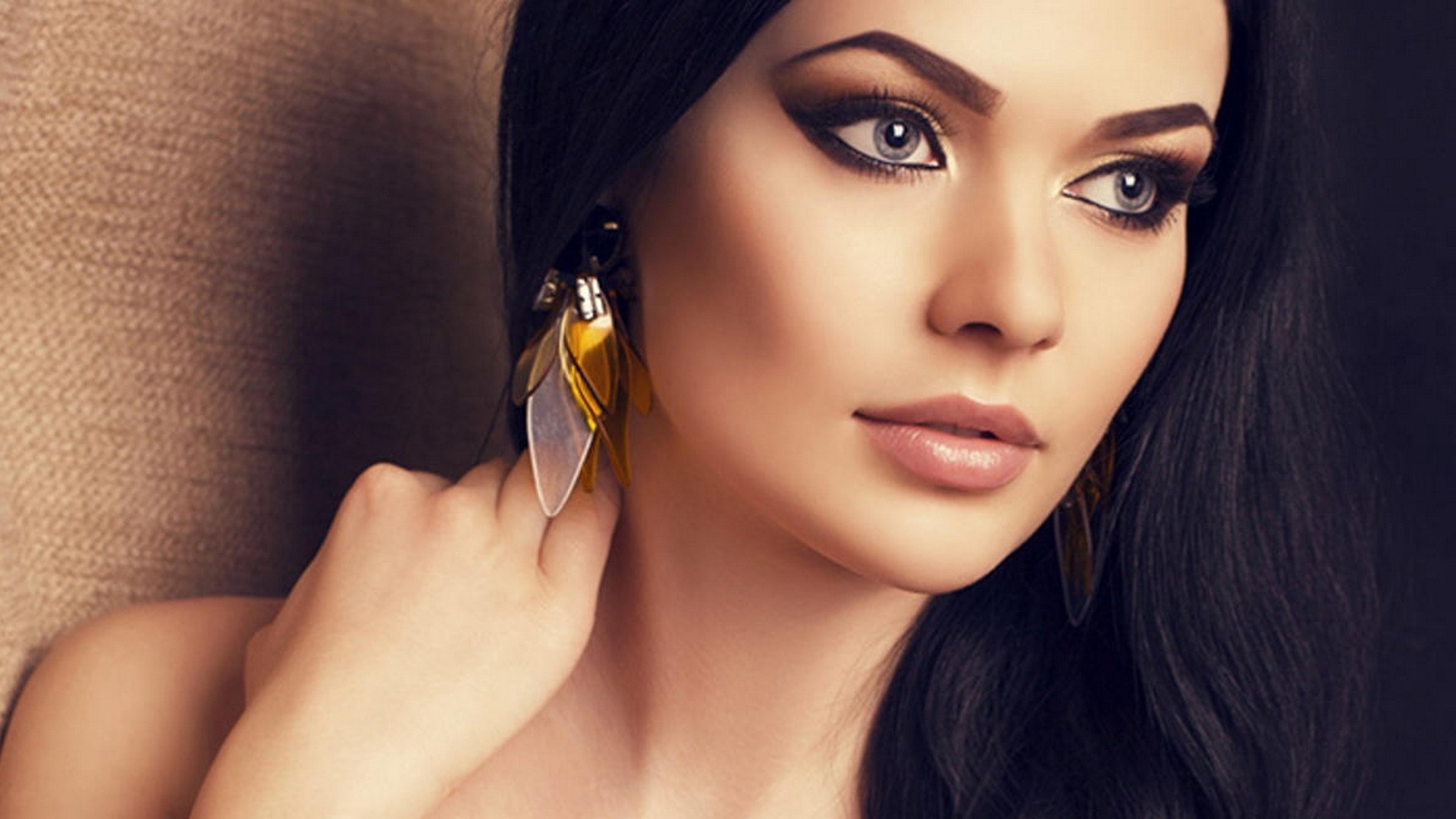 Woman with dramatic makeup and large earrings HD Wallpaper