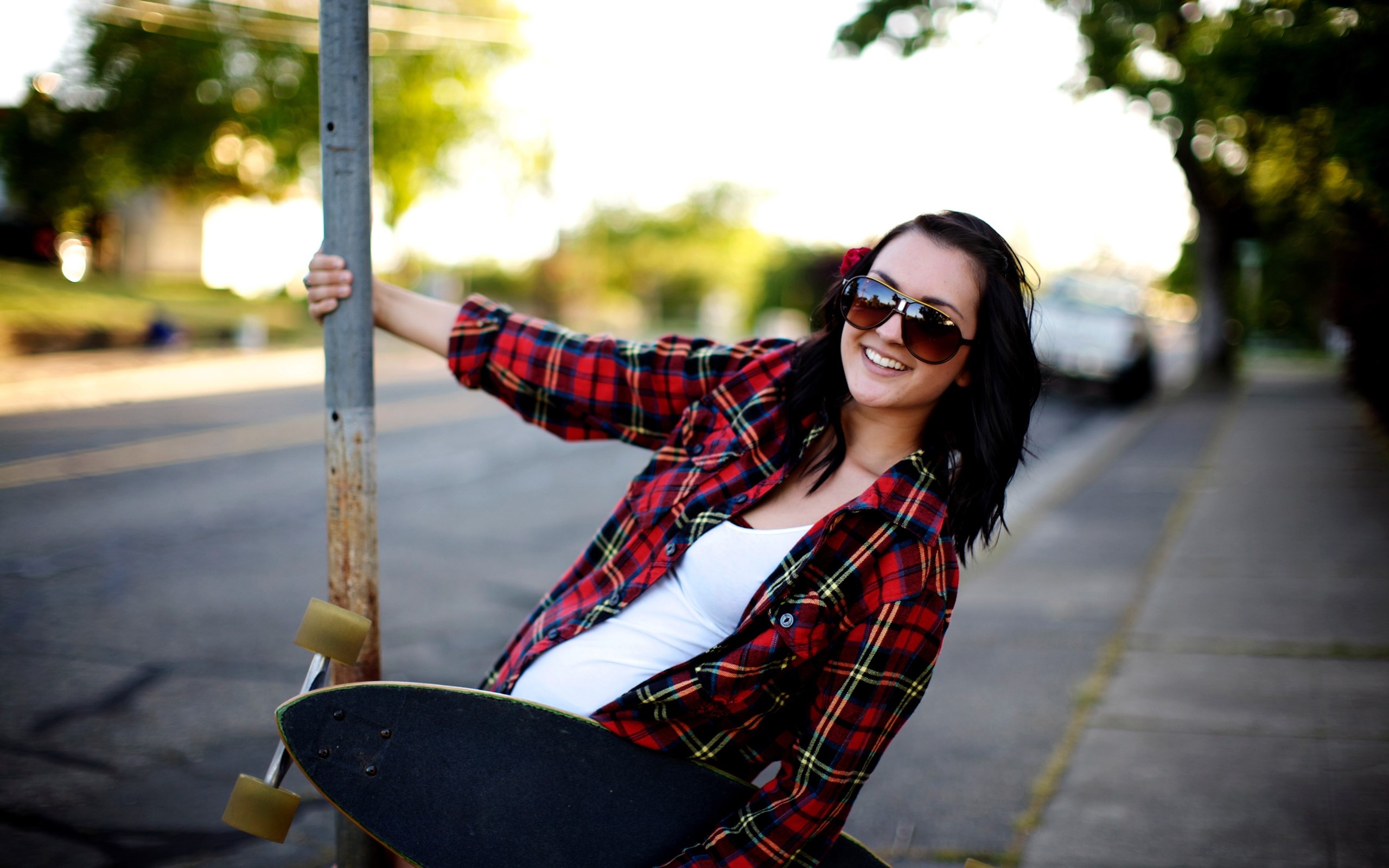 Woman with skateboard holding a pole HD Wallpaper