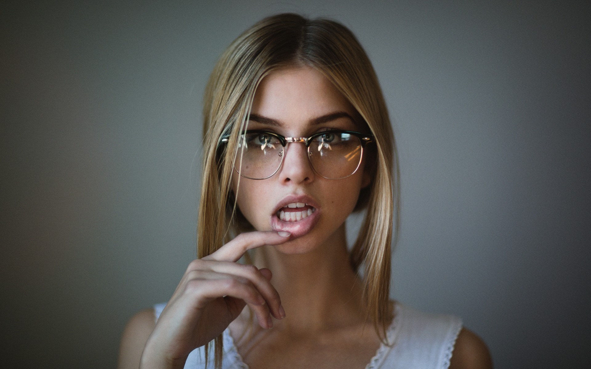 Woman wearing glasses with finger on lips HD Wallpaper