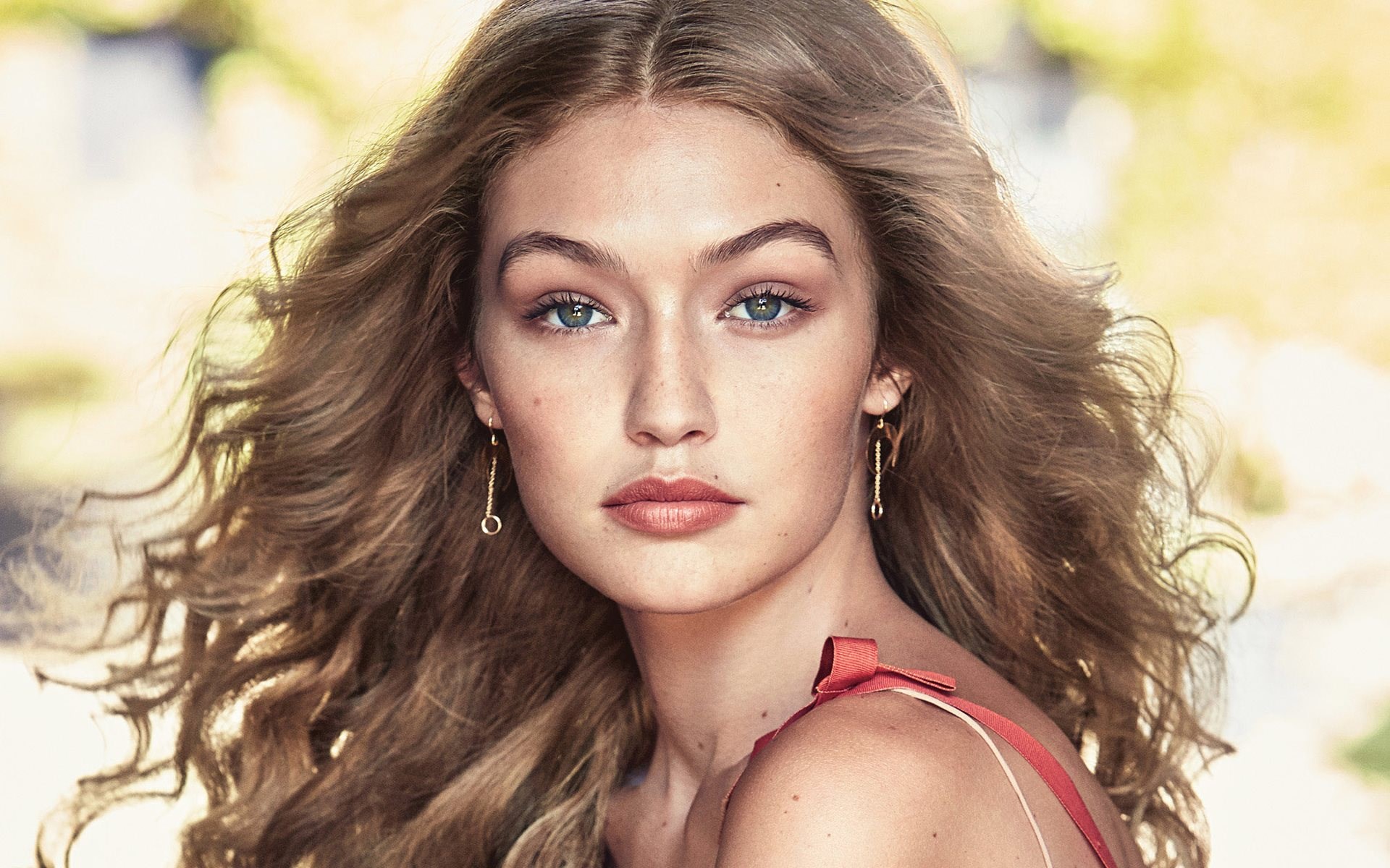 Gigi Hadid portrait with wavy hair and earrings HD Wallpaper