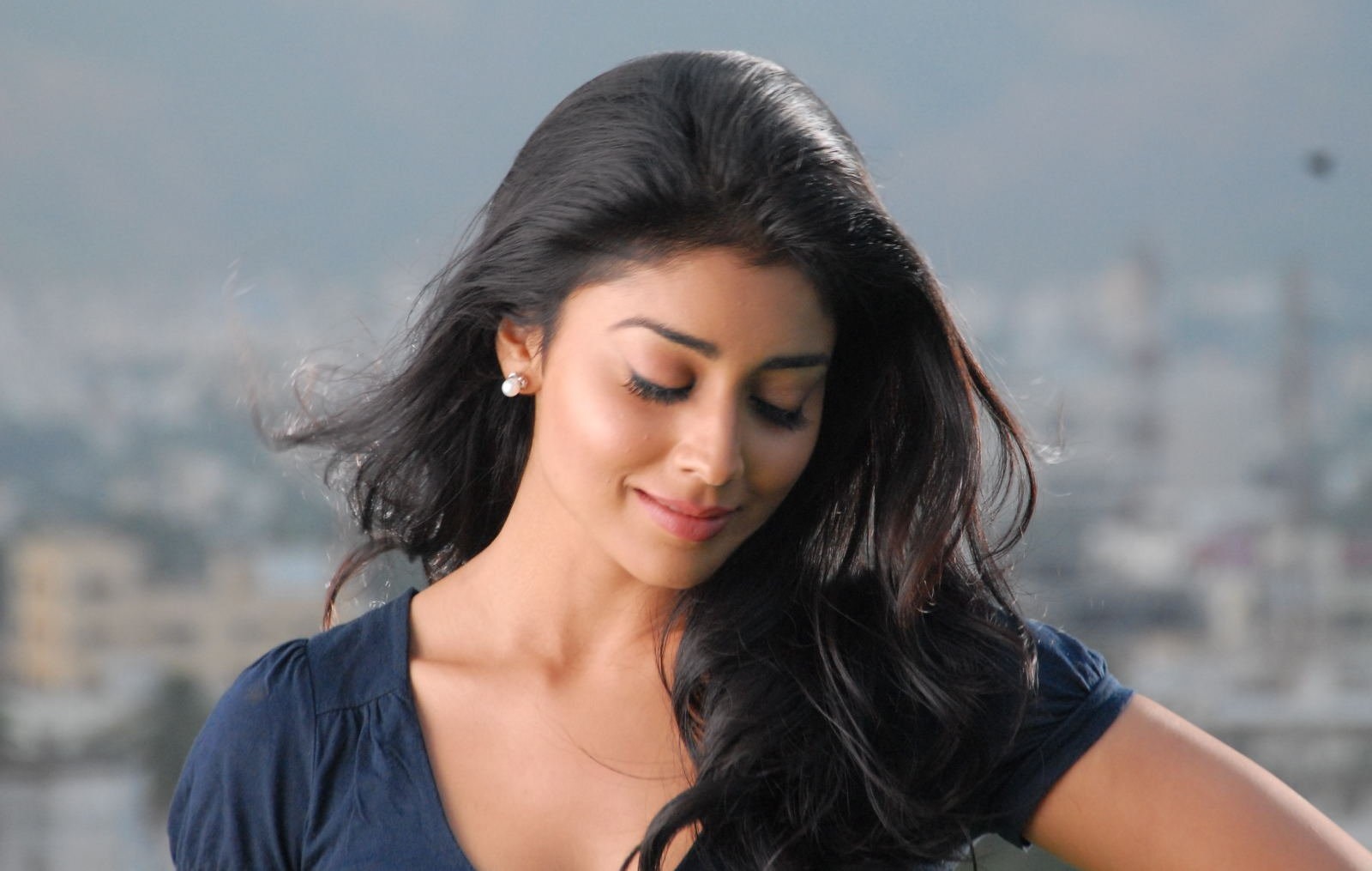Shriya Saran looking down with wind blowing her hair HD Wallpaper
