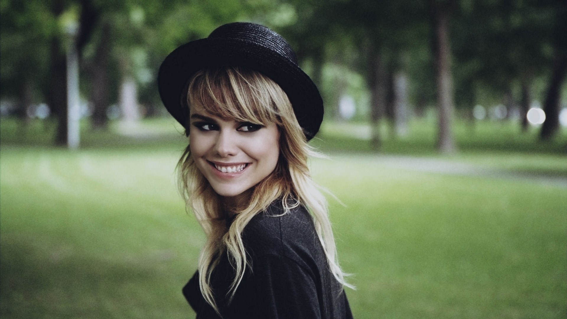 Woman wearing a black hat in a park HD Wallpaper