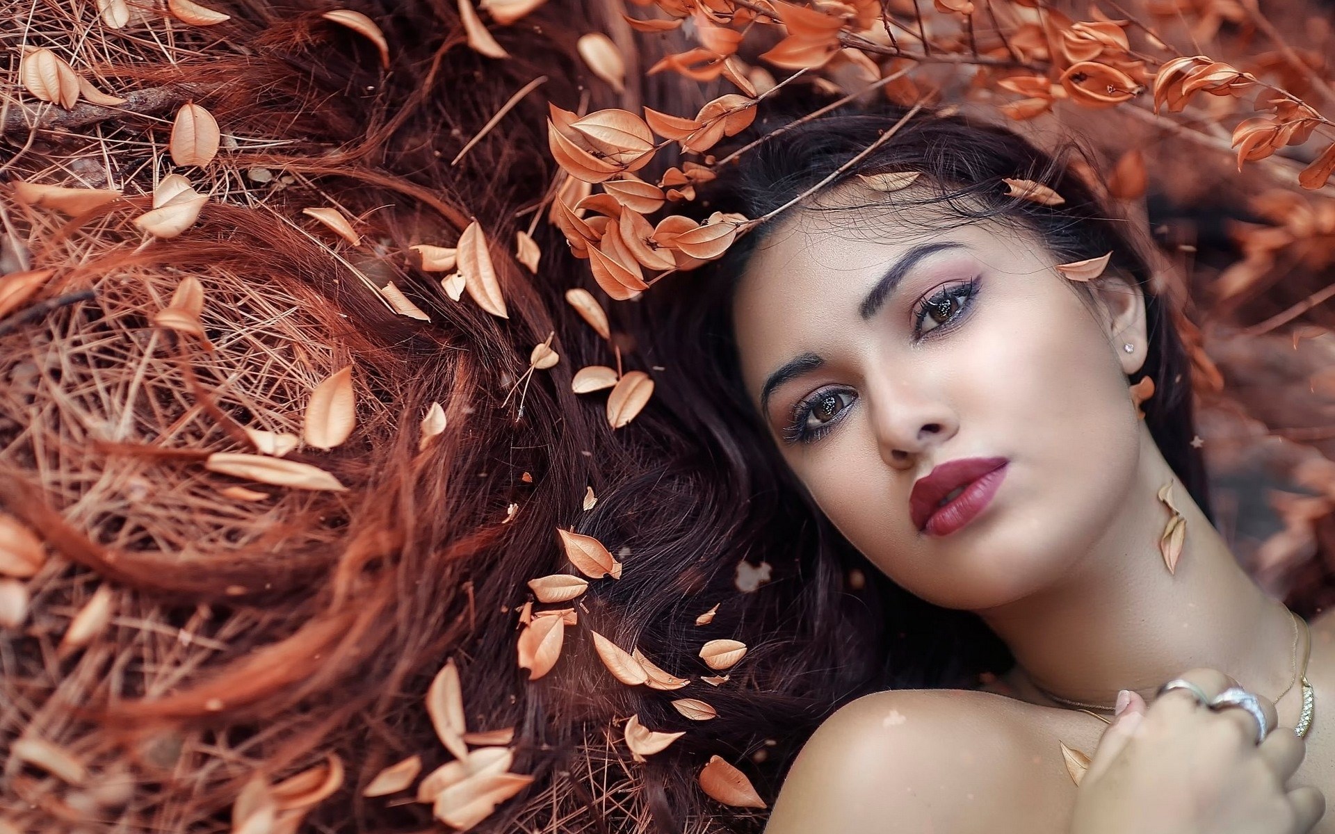 Woman with dark hair and autumn leaves HD Wallpaper