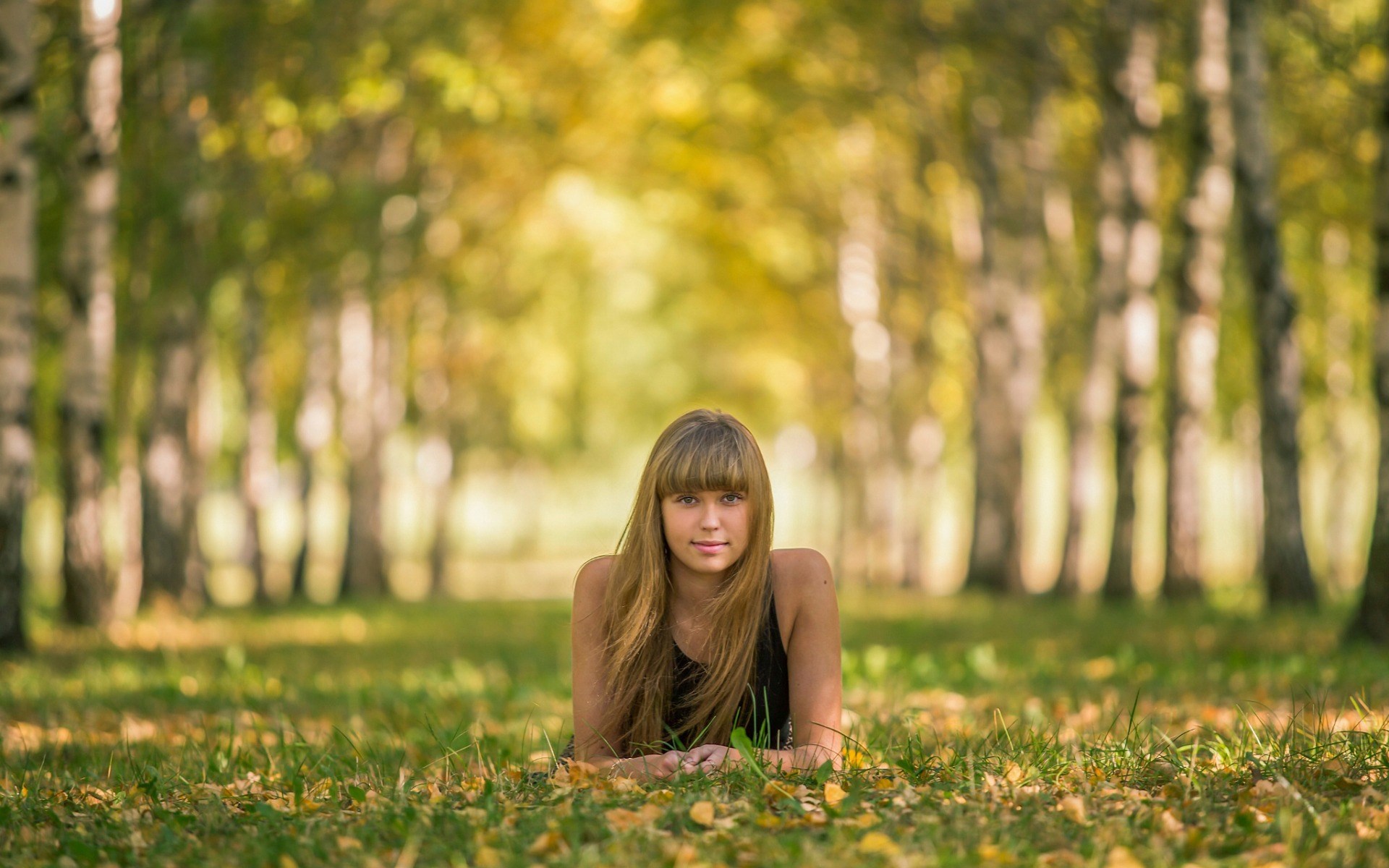 Young woman lying on grass in a park HD Wallpaper