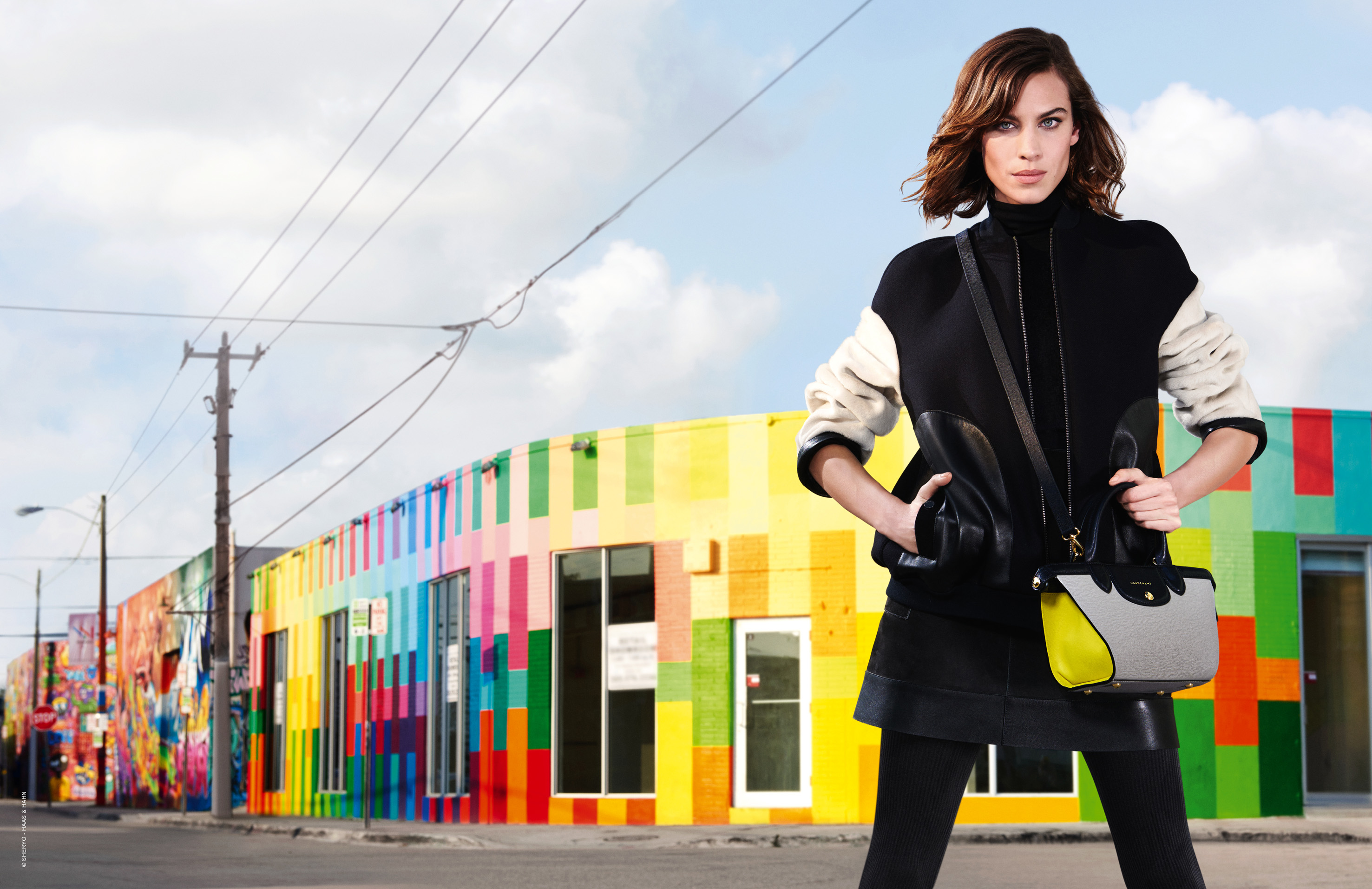 Alexa Chung with Longchamp bag in front of colorful building HD Wallpaper