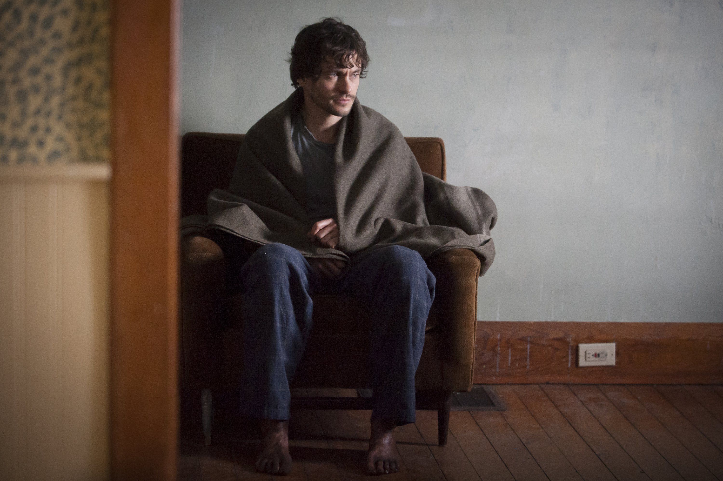 Hugh Dancy sitting wrapped in a blanket HD Wallpaper