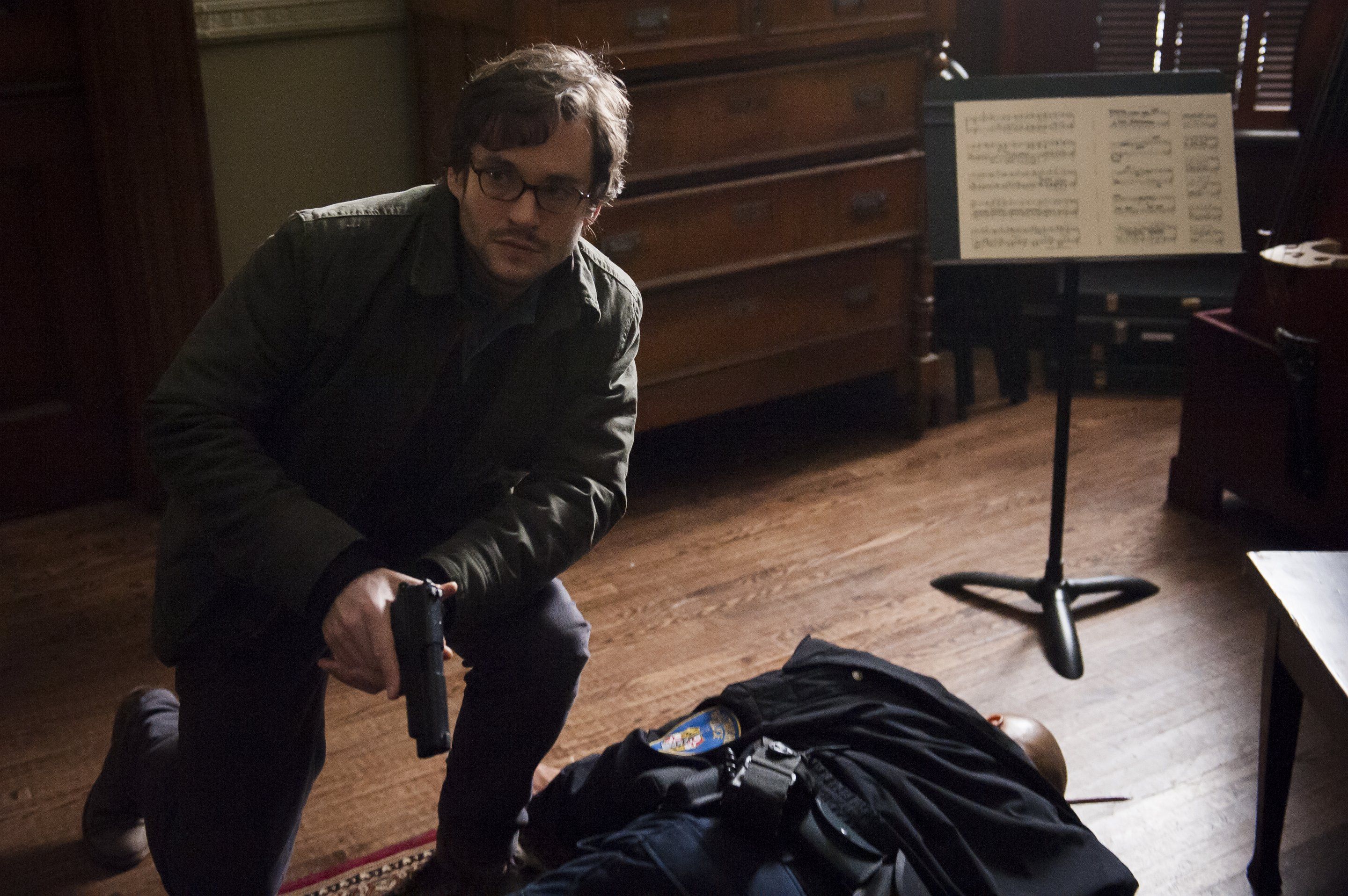 Hugh Dancy with a gun over a fallen person HD Wallpaper
