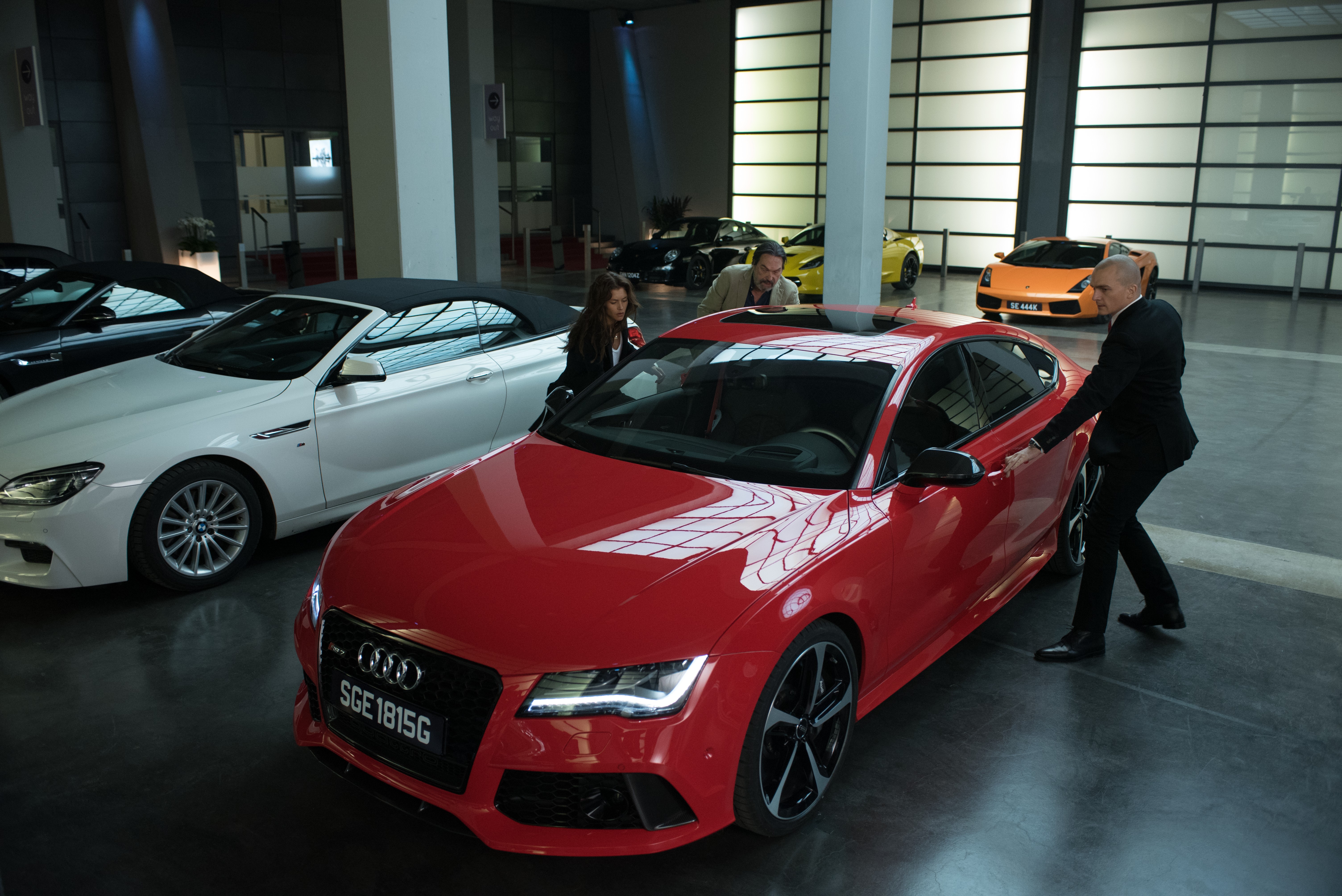 Hannah Ware in a car showroom with luxury cars HD Wallpaper