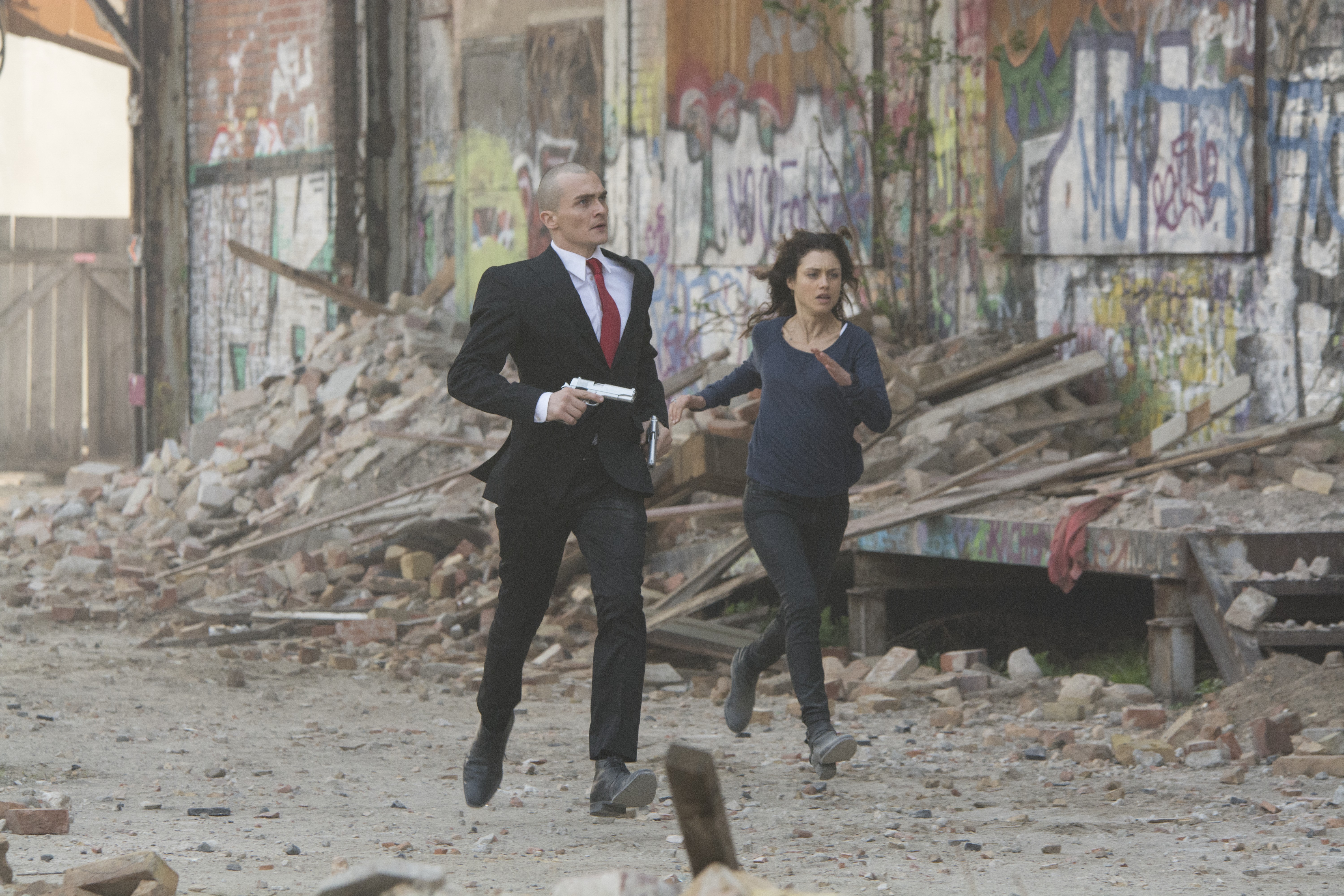 Agent 47 and Hannah Ware running in destroyed city HD Wallpaper