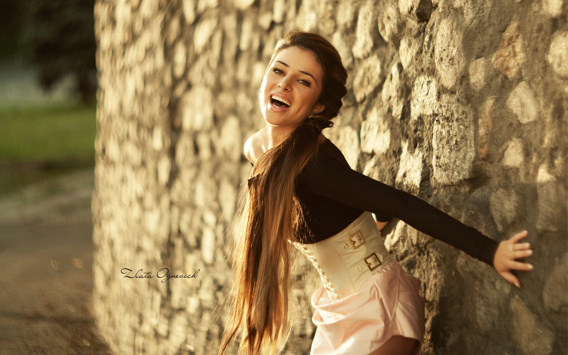 Woman in corset leaning against stone wall HD Wallpaper
