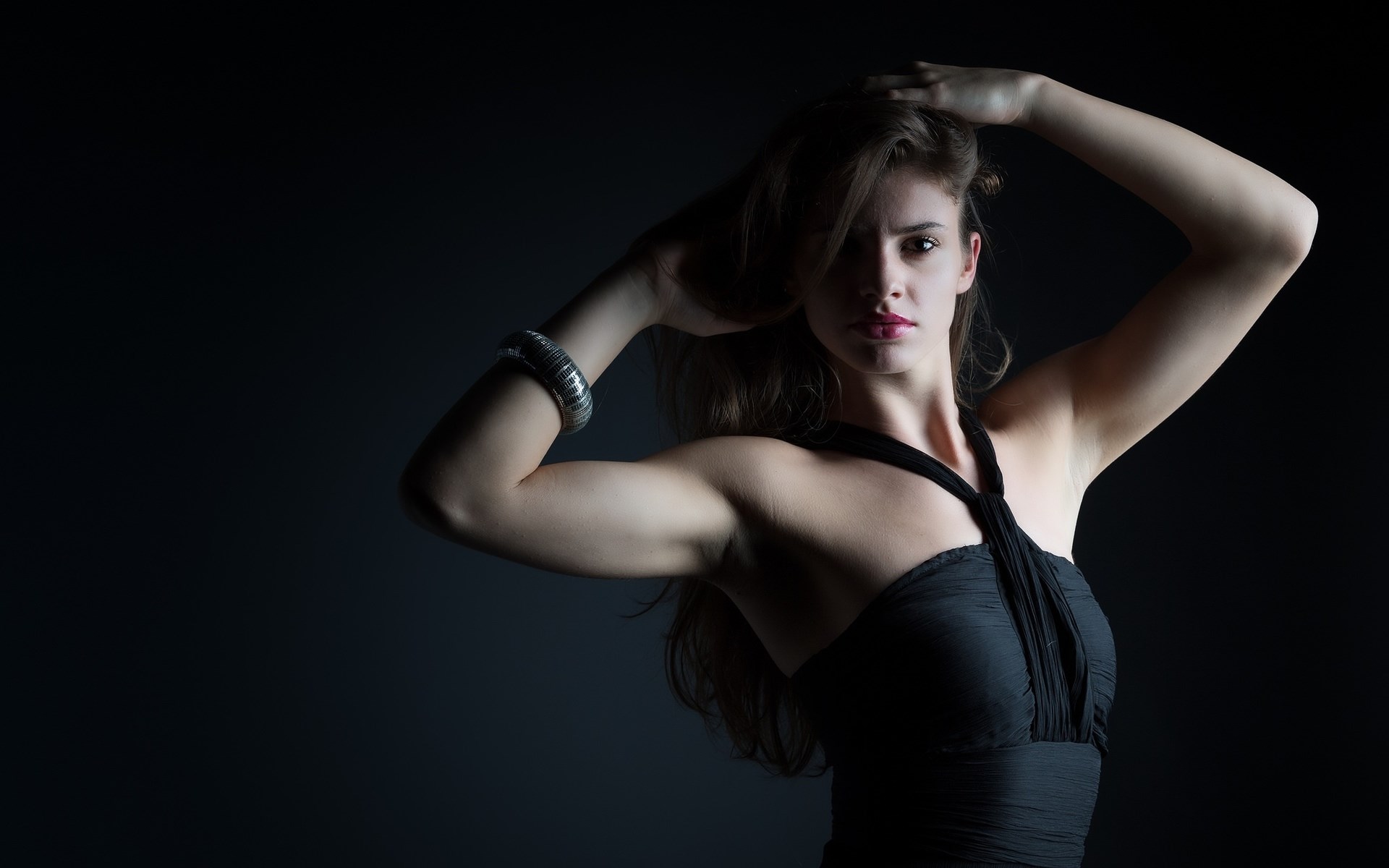 Woman in black dress with hands in hair HD Wallpaper