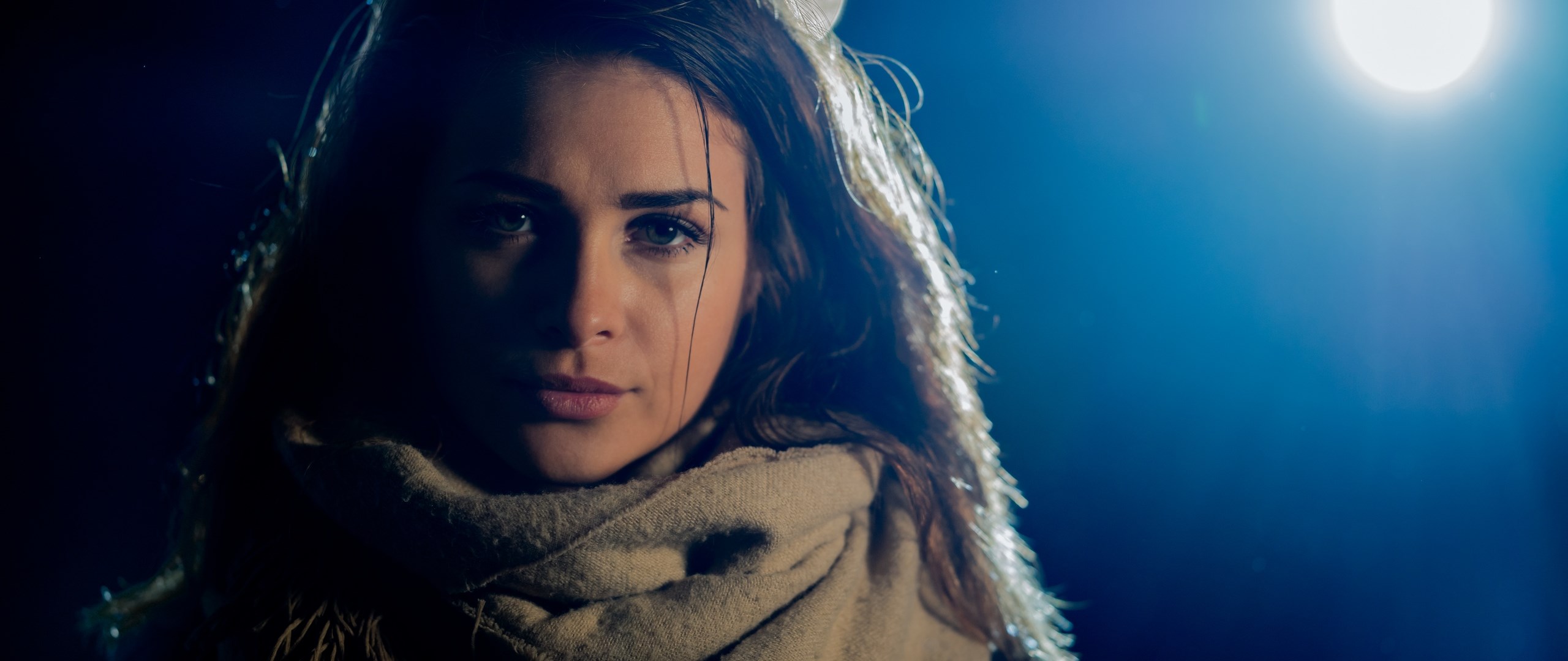 Woman in scarf under spotlight HD Wallpaper