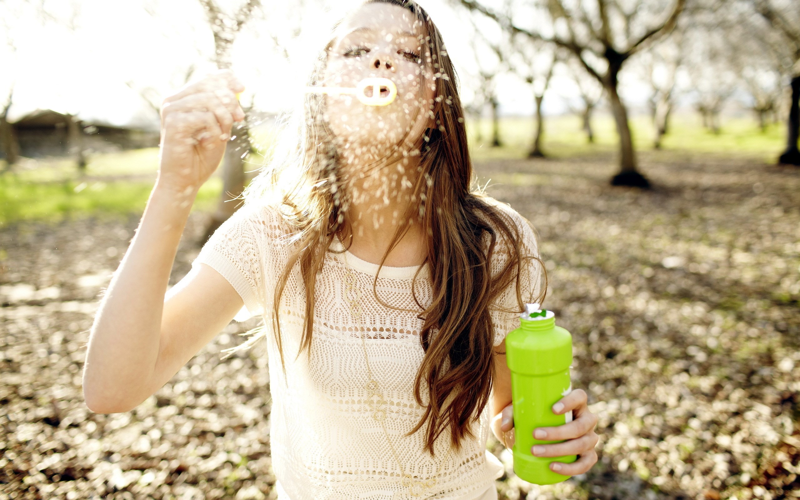 Girl blowing bubbles in a park HD Wallpaper